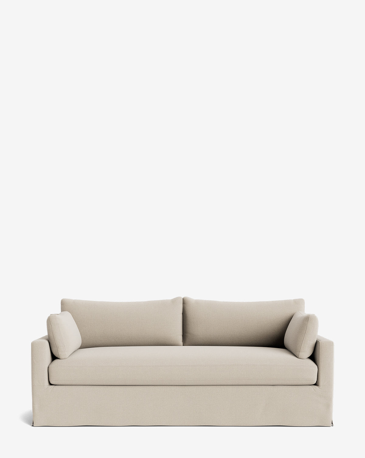 A Peterson Classic Slipcover Sofa (75-100) in light beige with a skirted base, straight arms, feather blend cushions, and two cylindrical side pillows is set against a plain white background by Vendixs