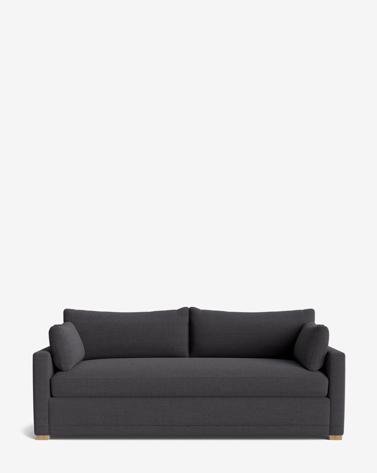 The Peterson Classic Upholstered Sofa (75 - 100) is a modern dark gray sofa with plush cushions, two seat and back pillows, and two cylindrical side pillows. Handcrafted with straight arms and wooden feet, shown against a plain white background by Vendixs