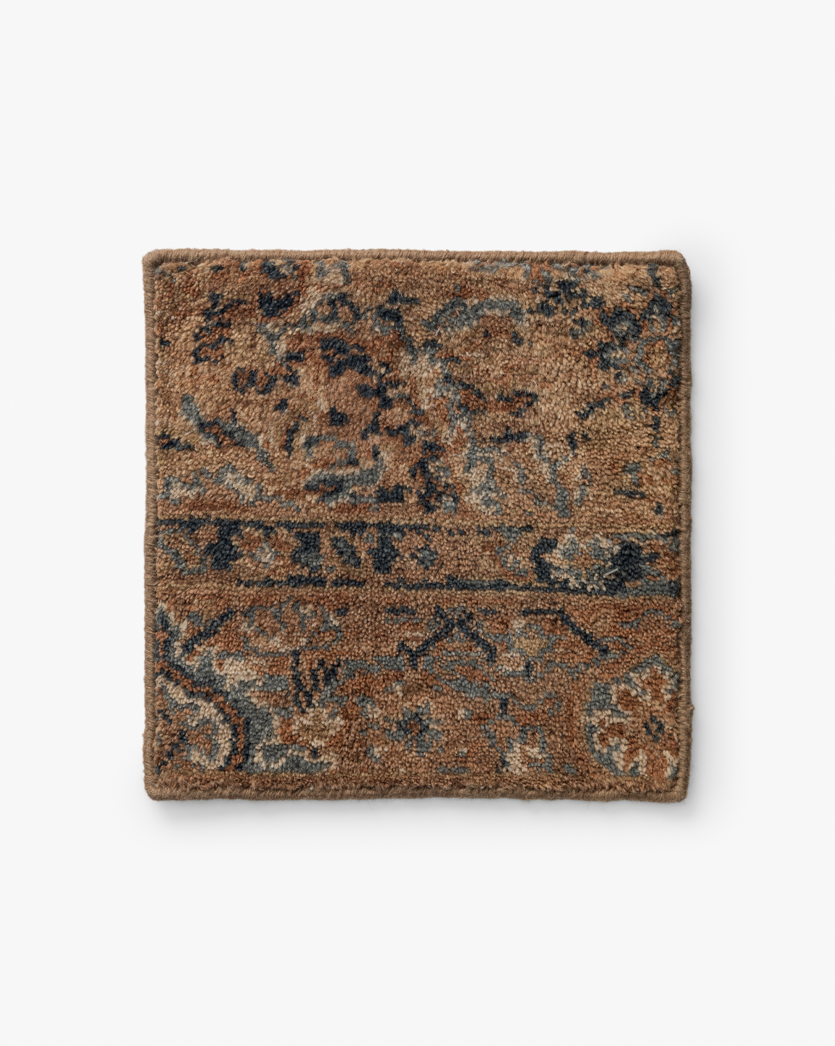 The Piedmont Hand-Knotted Wool Rug Swatch features a square sample of textured brown carpet with intricate, vintage-style floral and geometric patterns in blue and gray, highlighting heirloom craftsmanship on a white background, by Vendixs