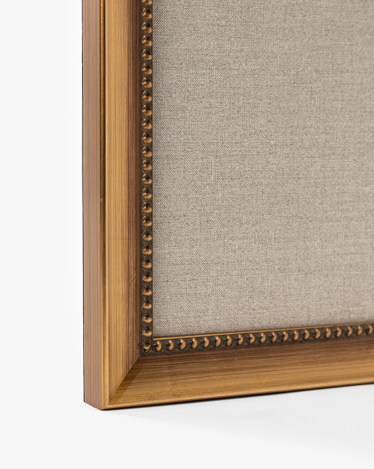 A close-up of the corner of a wooden frame with gold detailing and beaded inner edge displays Purple Irises in Vases. The warm brown finish, light beige fabric, and plain white background make it perfect for elegant home decor, by Vendixs