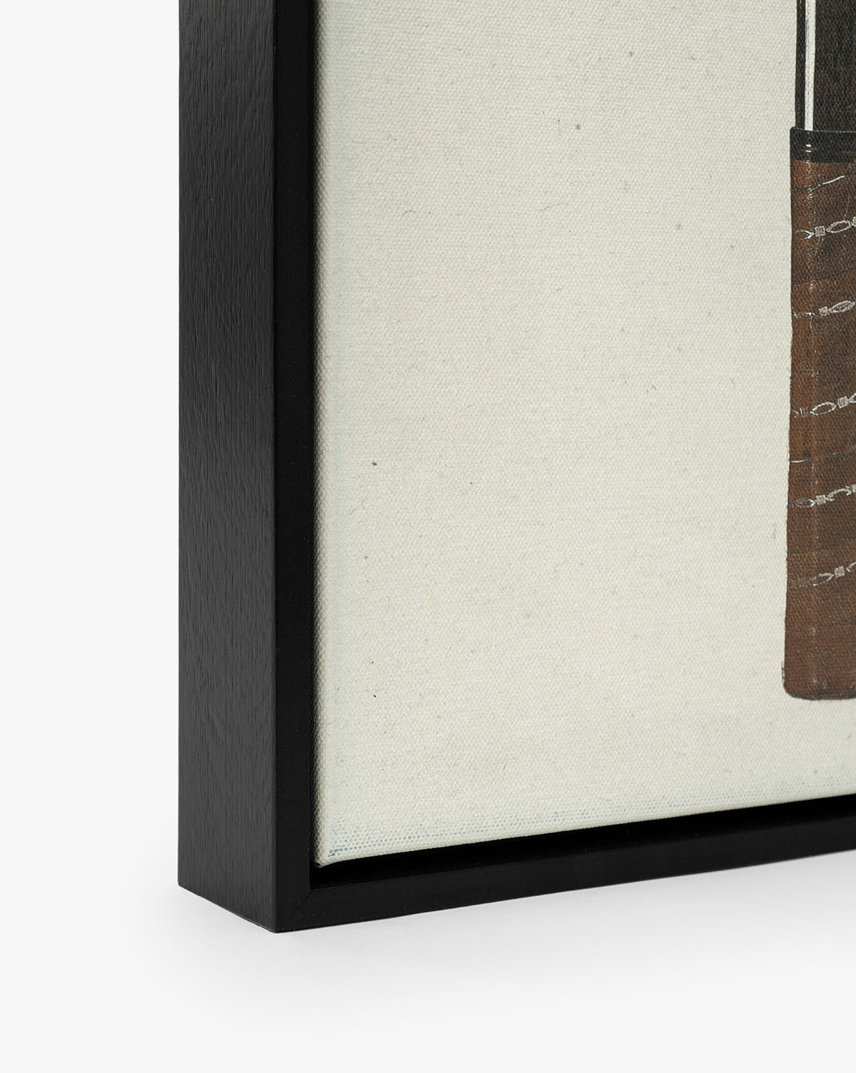Close-up of the Rackets 1 framed canvas artwork, featuring a black woodgrain frame, by Vendixs The mostly off-white canvas showcases part of a brown, textured shape for vintage wall art appeal.