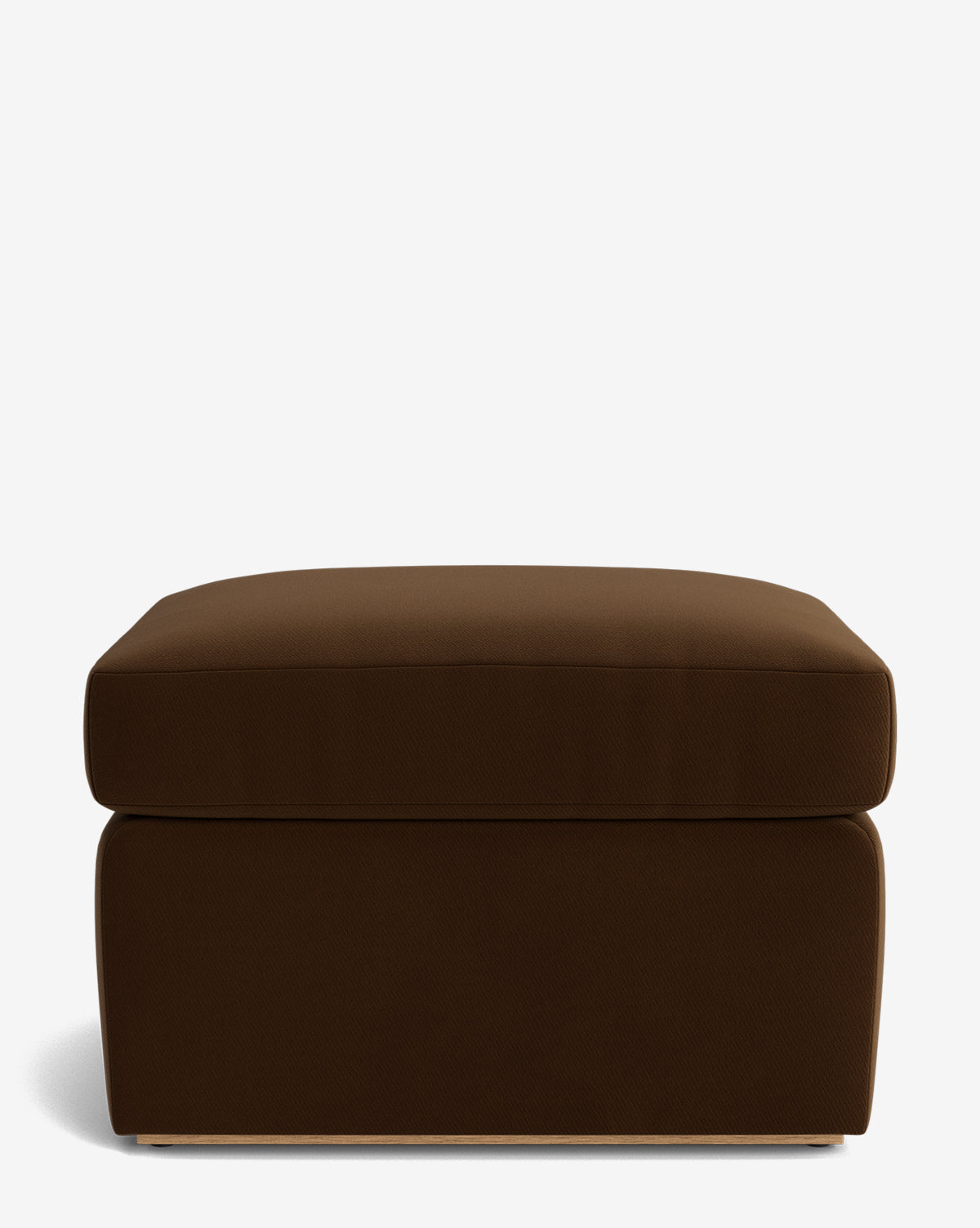 The Reese Ottoman is a rectangular, dark brown handcrafted piece with a down-wrapped cushioned top and modern design, shown on a plain white background by McGee & Co.