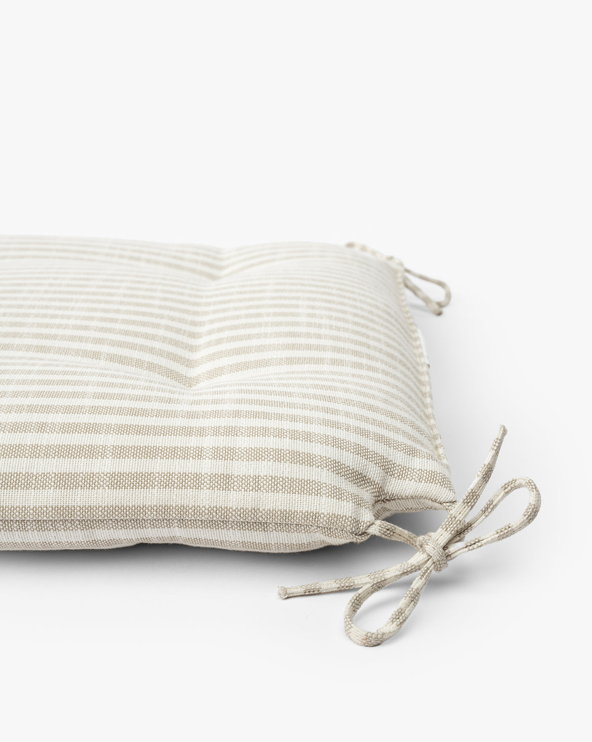 The Credence Romany Counter Stool Cushion features beige and white linen stripes, tufted details, and fabric corner ties to fit your stool, shown on a white background. Vendixs