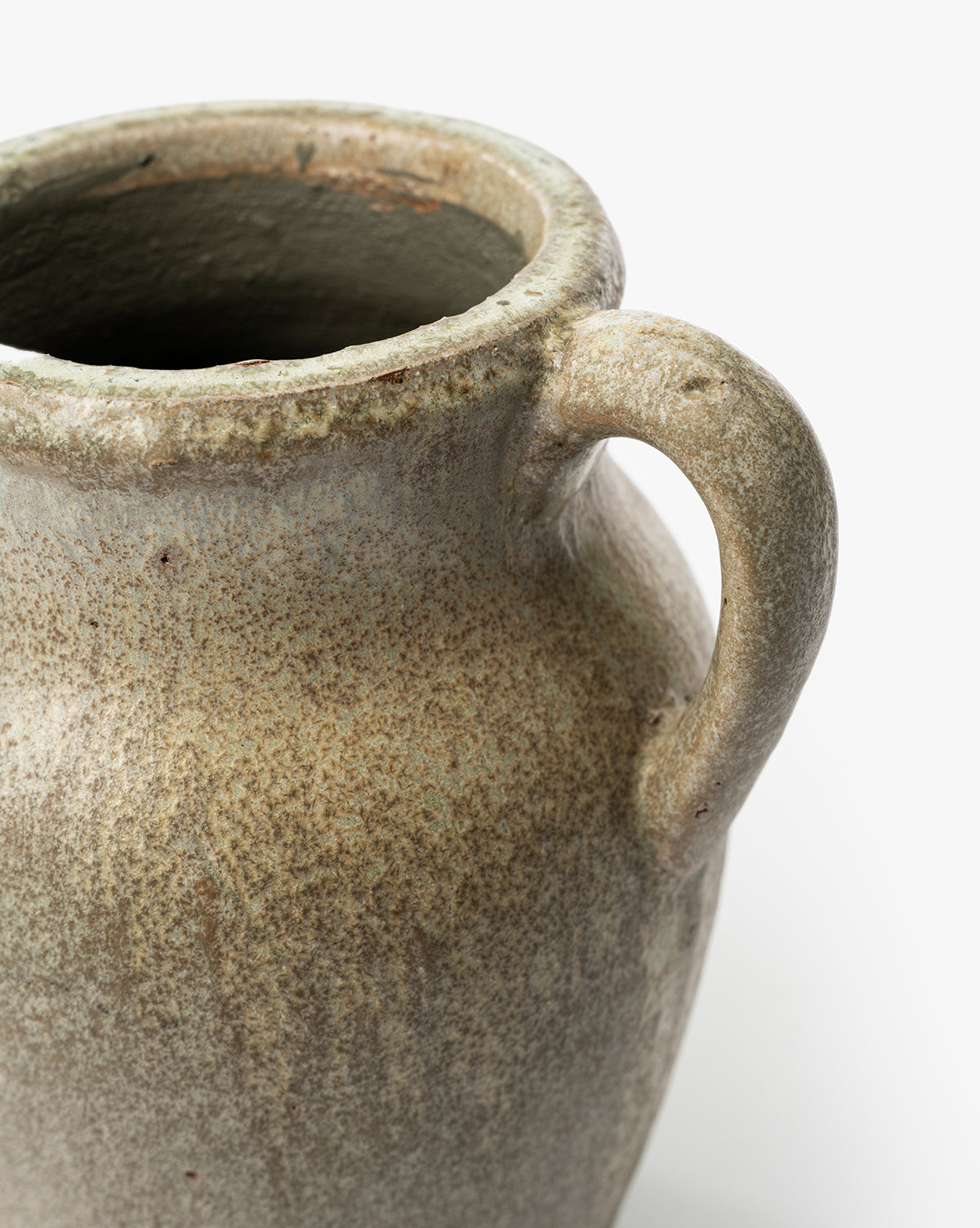 A close-up of the Sabine Pitcher Vase, a vintage-inspired ceramic jug with a single handle, speckled earthy glaze, and rough texture, shown against a plain white background, by Vendixs