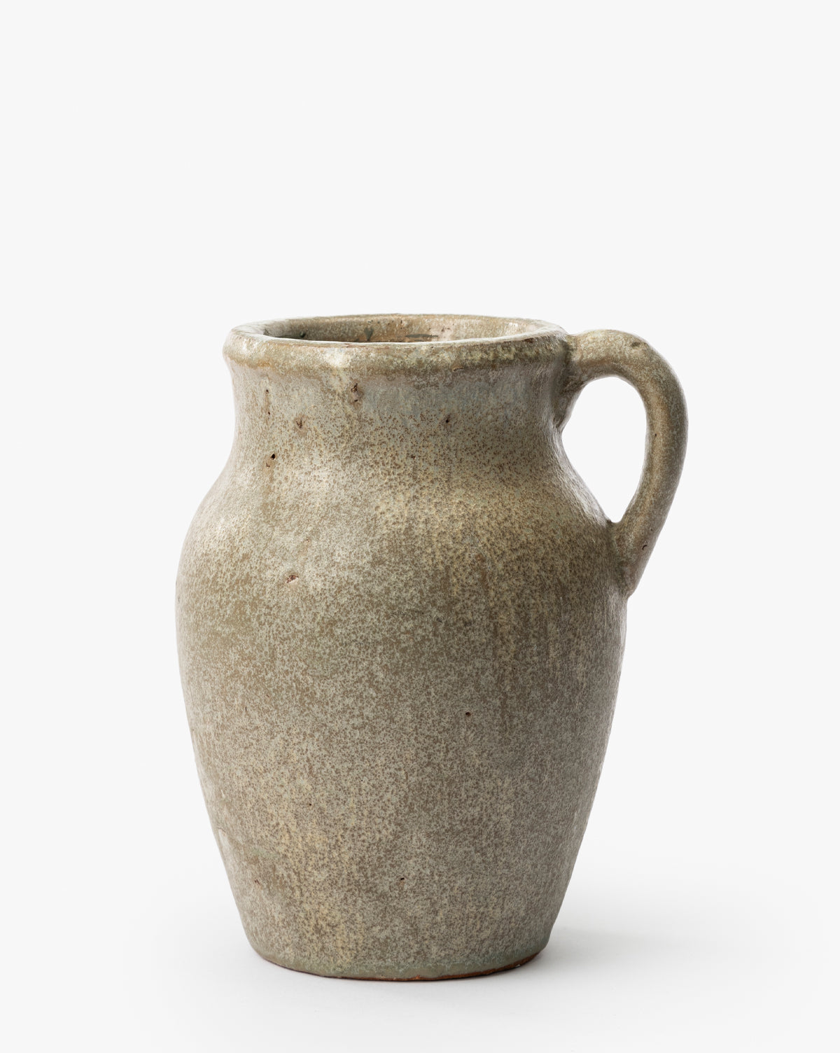 The Sabine Pitcher Vase is a rustic, glazed ceramic piece with a wide body, narrow neck, and single handle. Its earthy mottled gray-brown finish and handmade look stand out against a plain white background, by Vendixs