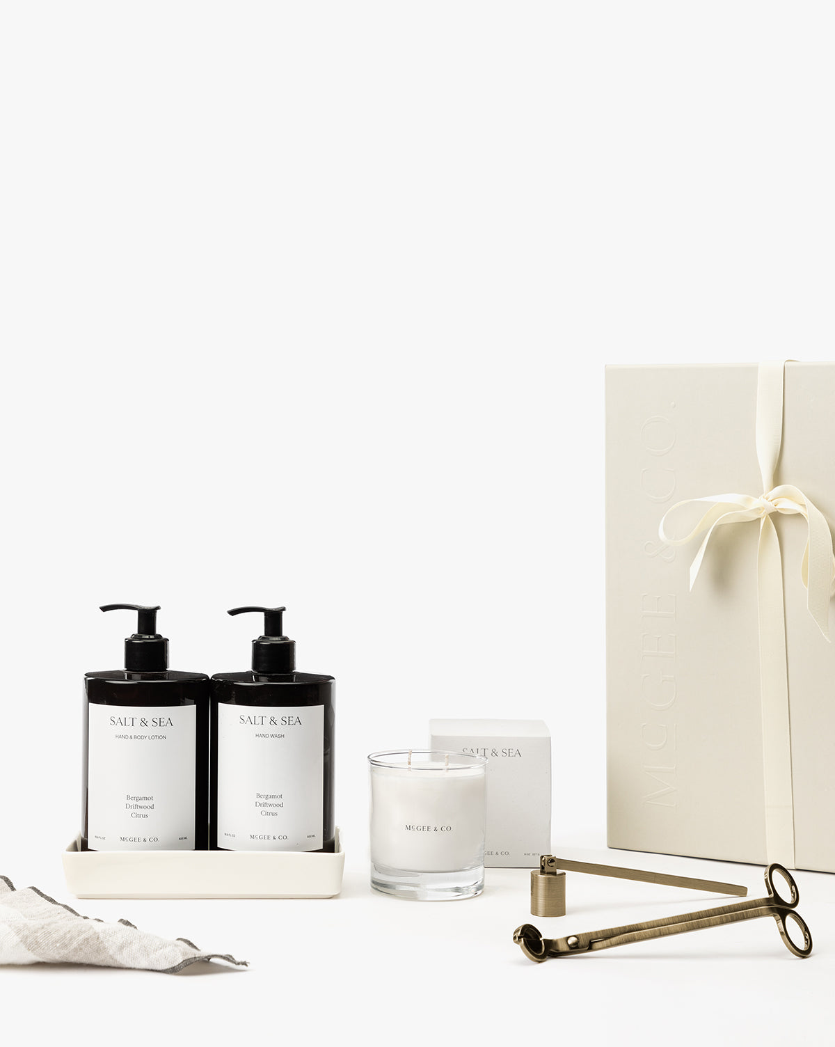 The Salt & Sea Gift Set features two pump bottles, a candle, a wick trimmer, and a ribbon-tied white box with minimalist white labels—ideal for bringing the signature scent of calm to your home spa, by Vendixs