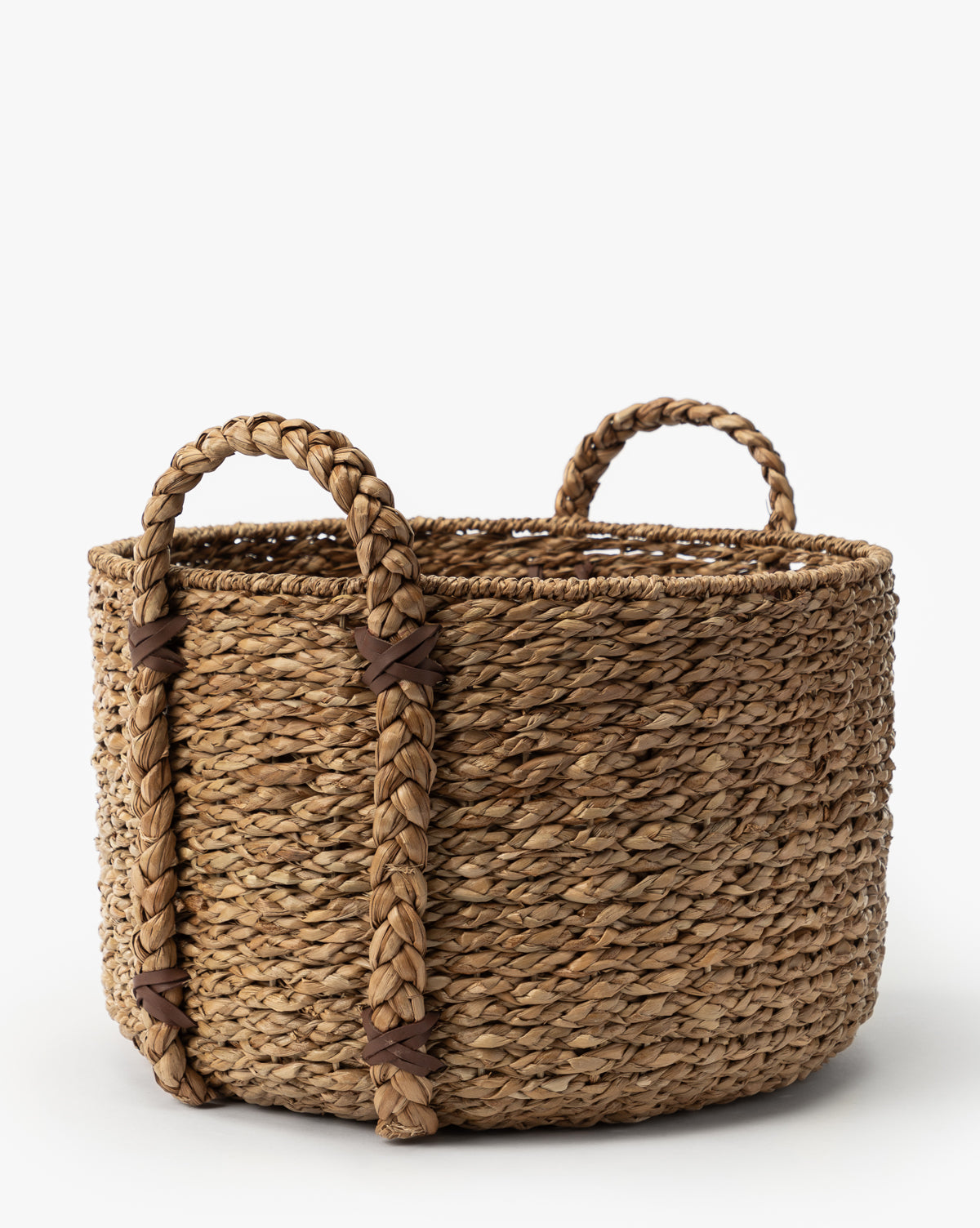 The Salter Woven Basket is a round seagrass storage basket with natural fibers and two thick, braided handles, featuring a rustic look against a plain white background, by Vendixs