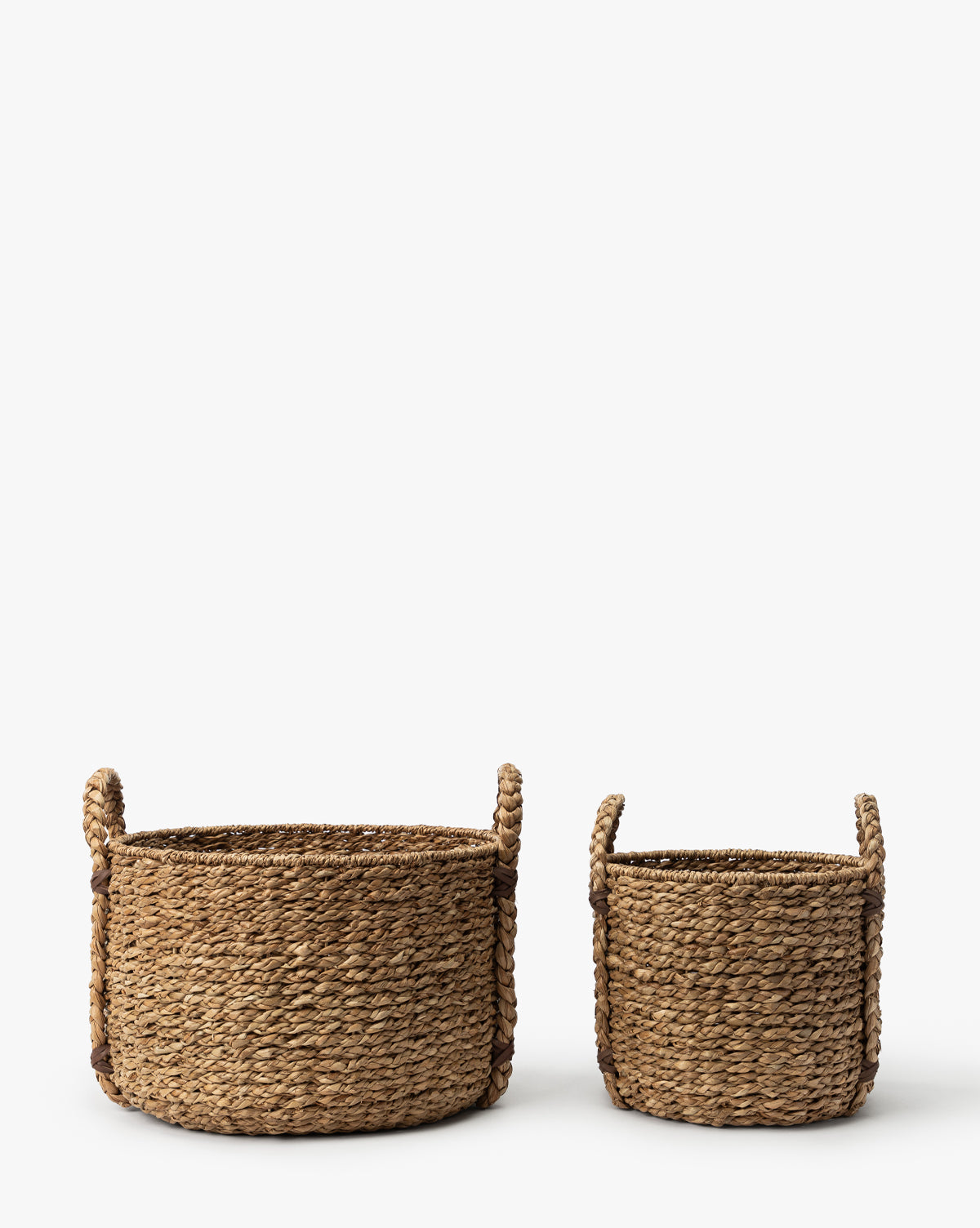 Two Salter Woven Baskets with handles, crafted from natural fibers, are side by side on a white background. The larger basket is on the left and the smaller one is on the right, by Vendixs