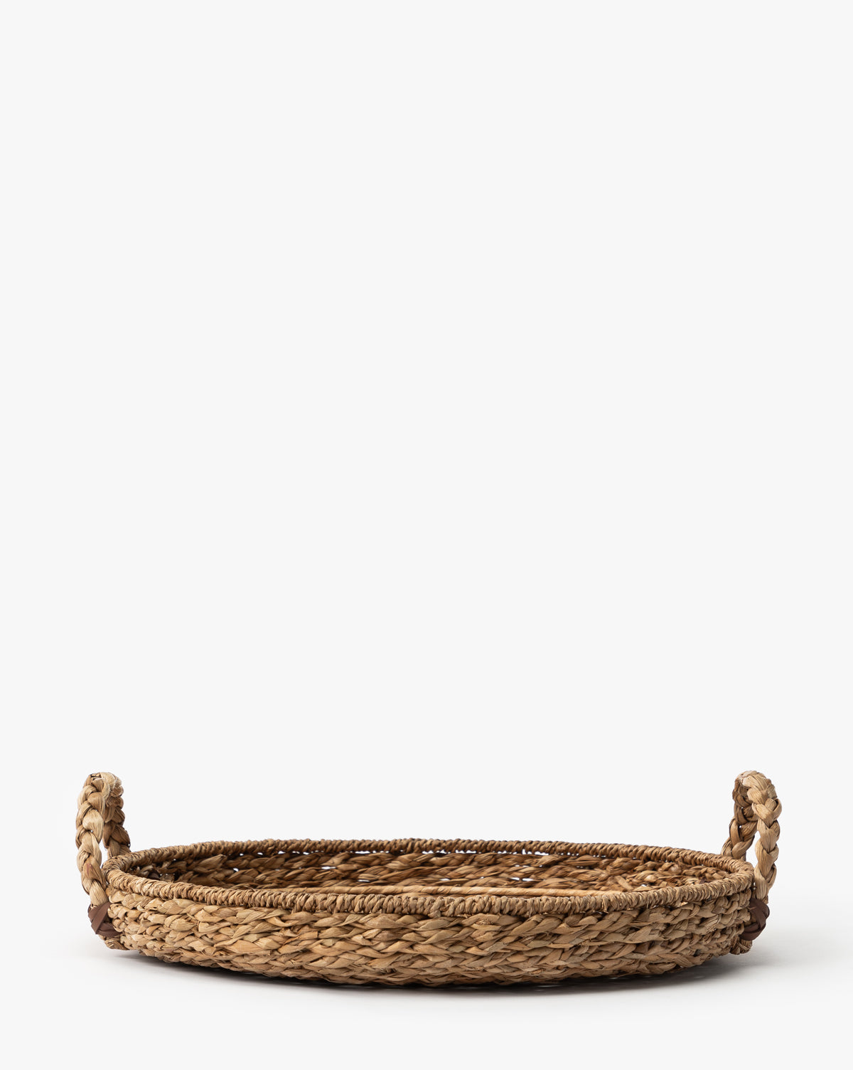 The Salter Woven Tray is a round, flat seagrass tray featuring two looped handles on each side, shown against a plain white background, by Vendixs