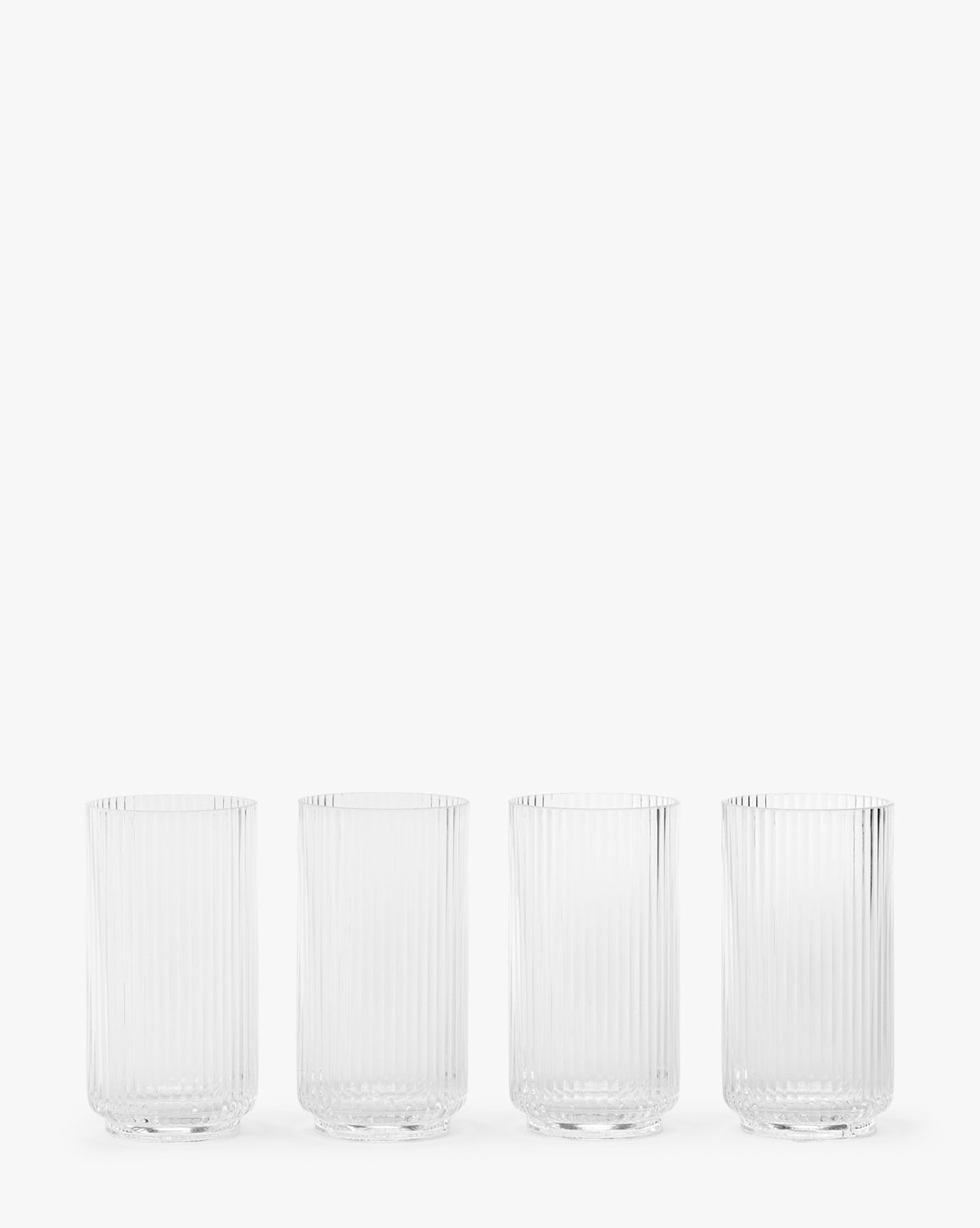 The Sanibel Acrylic Highball Drinking Glasses (Set of 4) feature vertical ribbed patterns and are arranged in a row against a plain white background, making them perfect for elegant outdoor table settings, by McGee & Co.