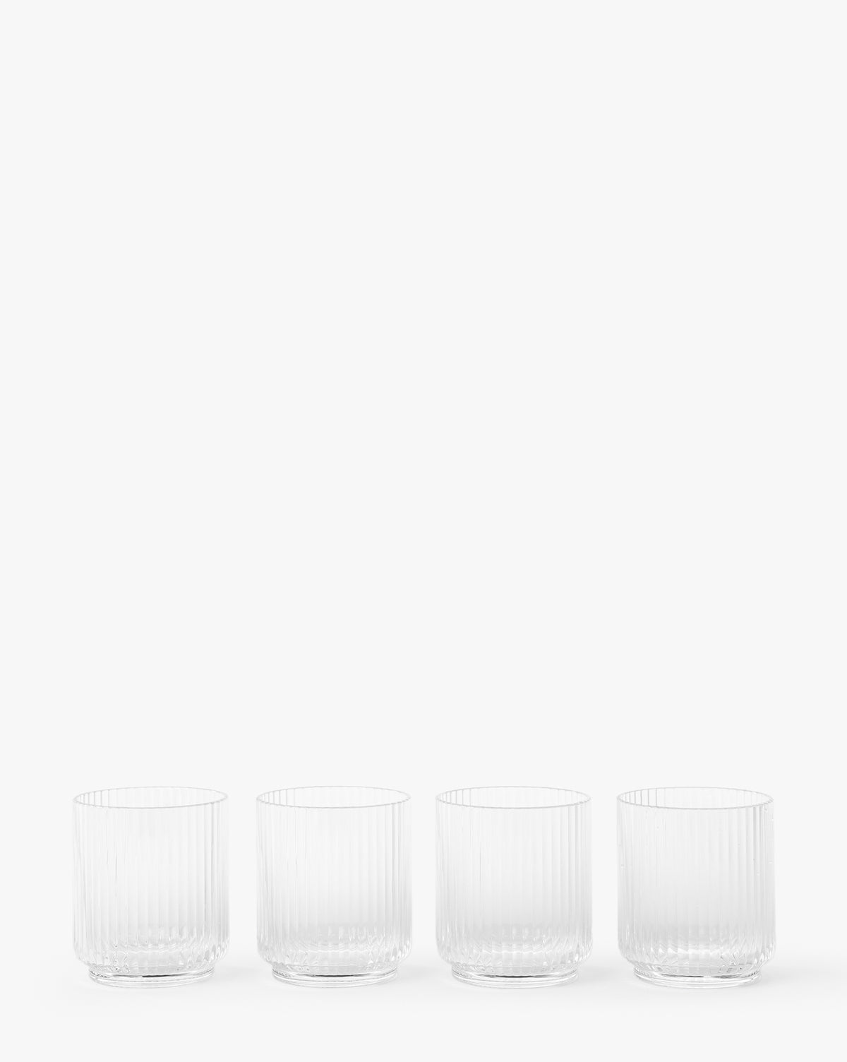 The Sanibel Acrylic Tumblers (Set of 4) feature a clear, vertical ribbed design and are shown in a row against a white background—ideal for stylish outdoor table settings.