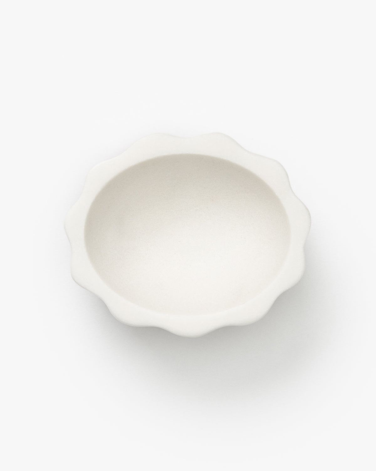 The Scalloped Marble Bowl is a small, round, white bowl with wavy, scalloped edges, displayed against a plain white background by Vendixs
