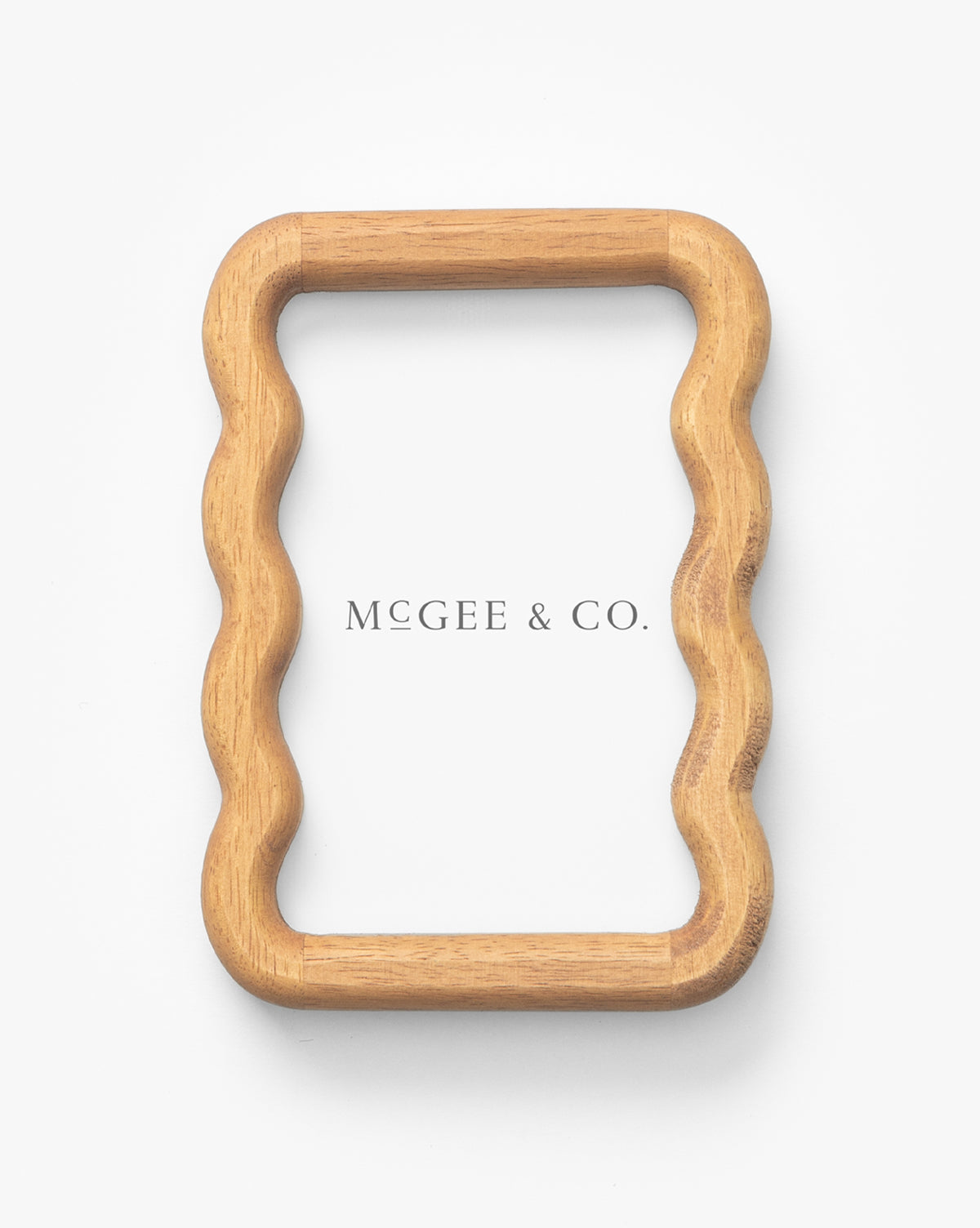 A rectangular Scalloped Wood Frame with gently wavy sides is crafted from natural rubberwood and displayed on a white background. Scalloped Wood Frame is centered inside, making it an elegant addition to your interior decor by Vendixs