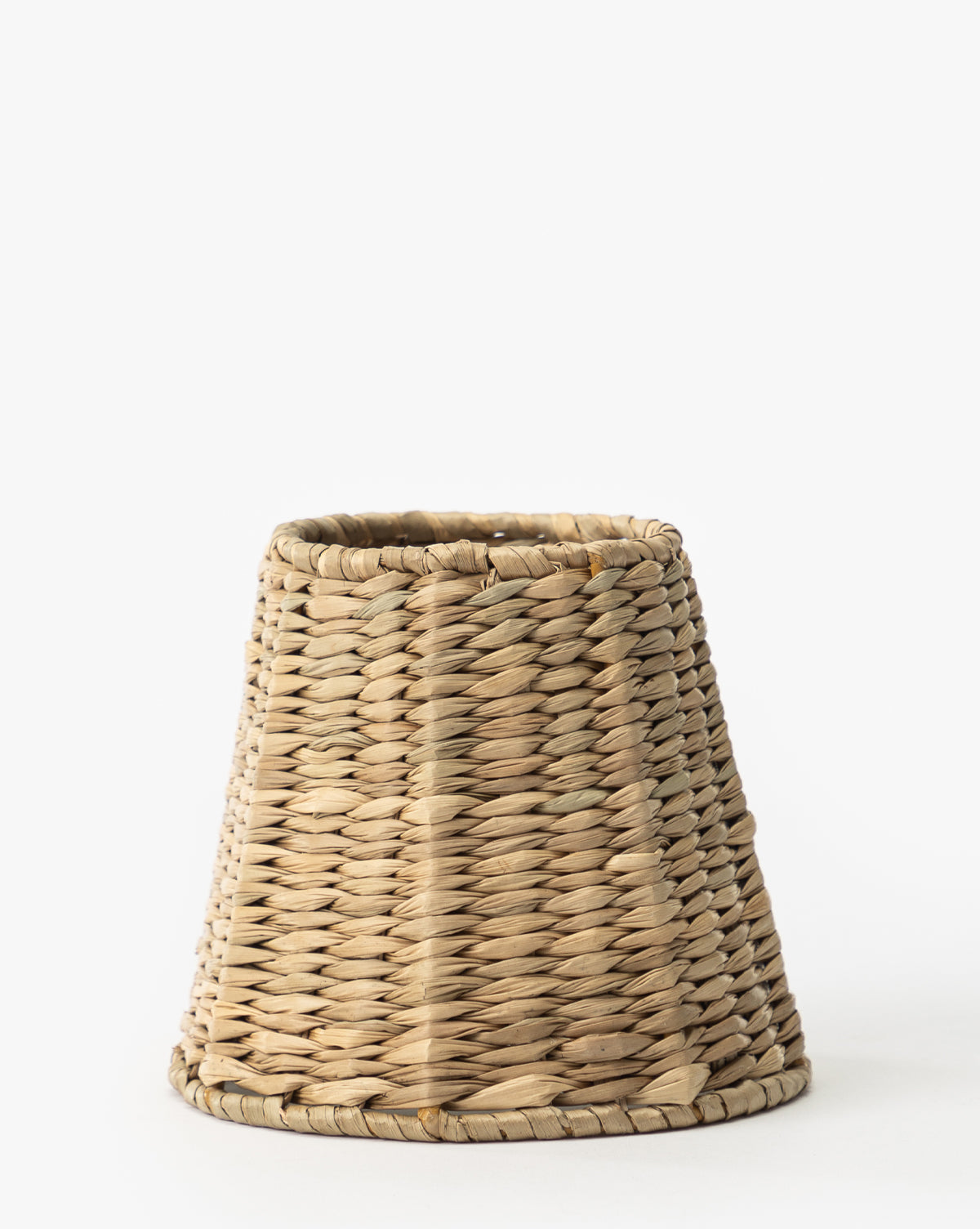 The Zafferano America Seagrass Lamp Shade is a conical, handwoven light brown basket crafted from natural fibers and shown upright against a white background. Vendixs