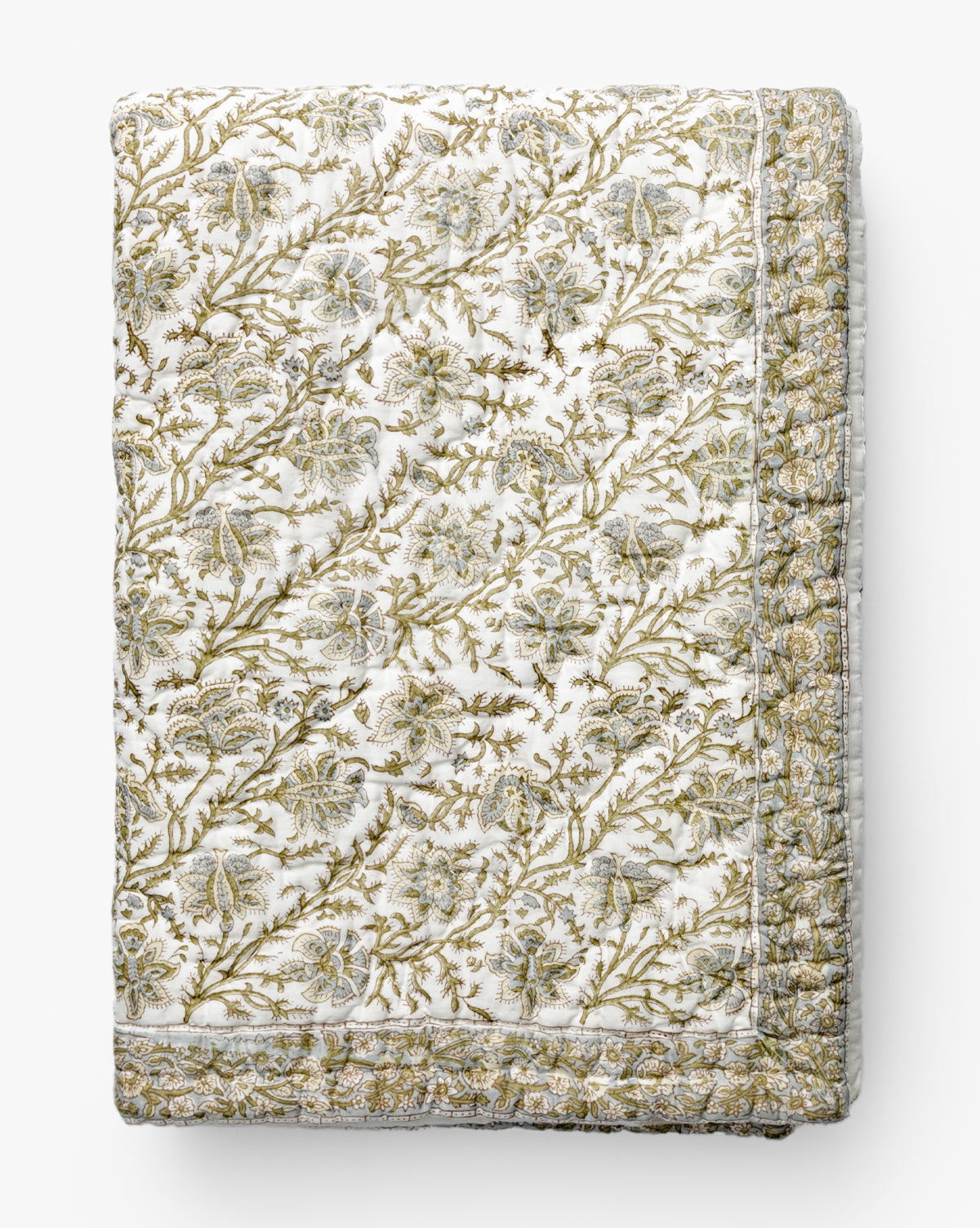 The Renuka Inc. Seton Kids Quilt features an intricate gold and green floral pattern on white, with stitched details and a decorative border, all neatly folded for display by Vendixs