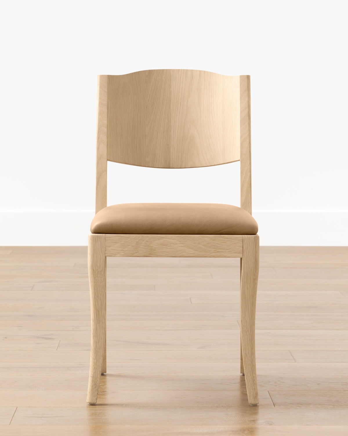 The Shepherd Dining Chair features a curved backrest and a tan upholstered seat, displayed on a wooden floor with a plain white wall background by McGee & Co.