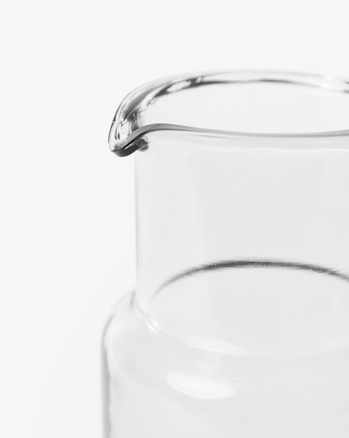 Close-up of the top portion of the Sienna Carafe, featuring a hand-blown glass design and spout, set against a plain white background by Vendixs