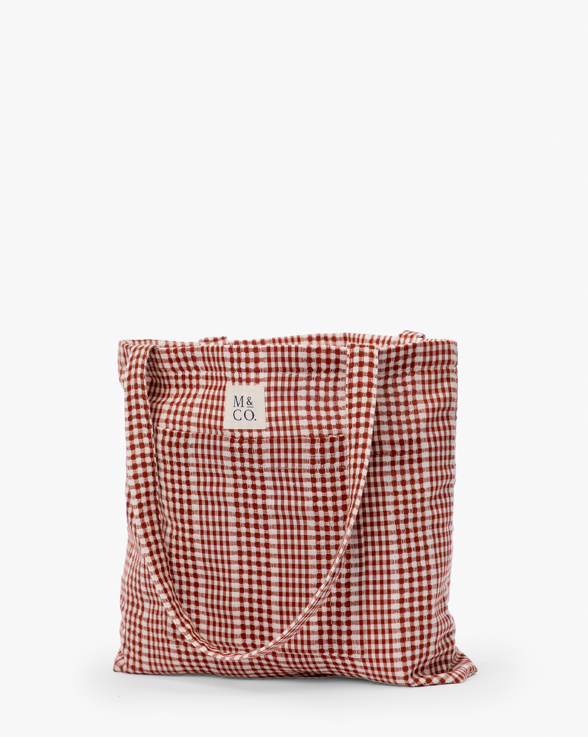 The Spencer Tote Bag is a casual tote with a red and white gingham check pattern, two handles, and a small square label reading "M & CO." at the top center, by Vendixs