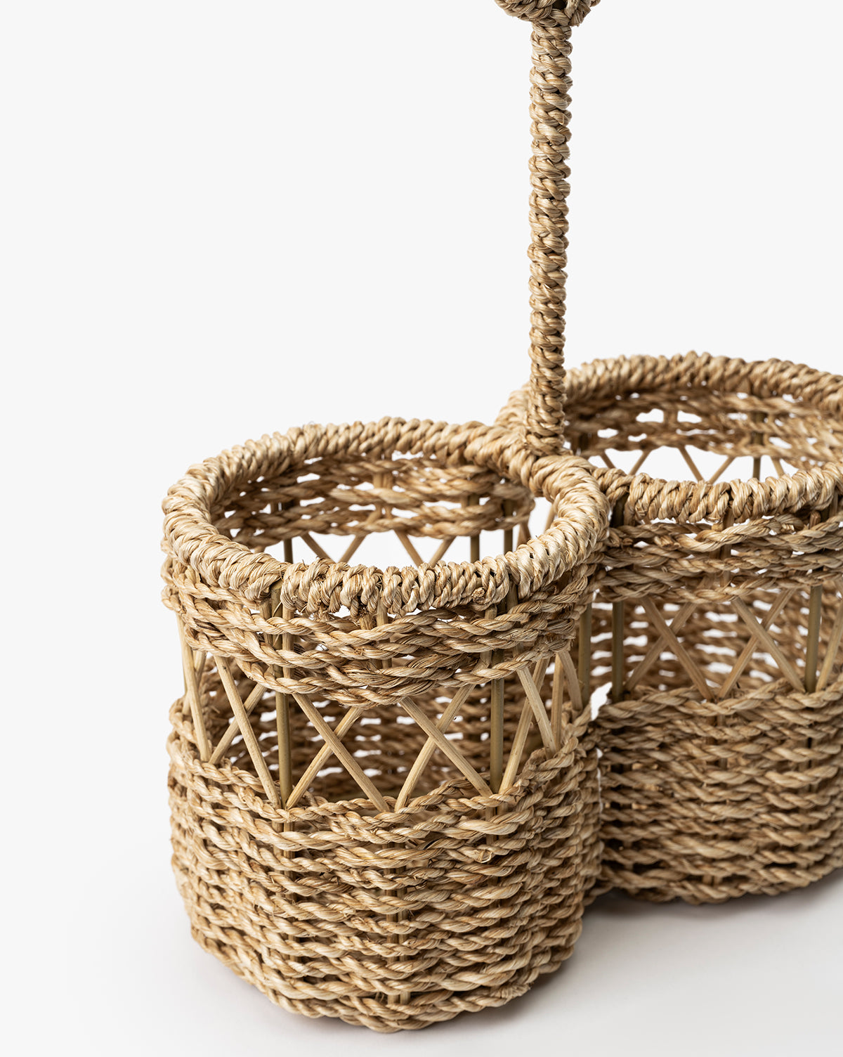Close-up of the Stokes Woven Caddy, a handwoven abaca wicker organizer with three cylindrical compartments, braided handle, and crisscross details—perfect for kitchen counters. Shown against a plain white background, by McGee & Co.