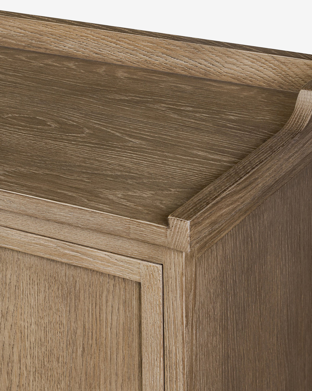 Close-up of the Stonington Oak Sideboards top corner featuring a light brown, weathered oak finish with visible wood grain and a raised edge detail along the back and side, by McGee & Co.