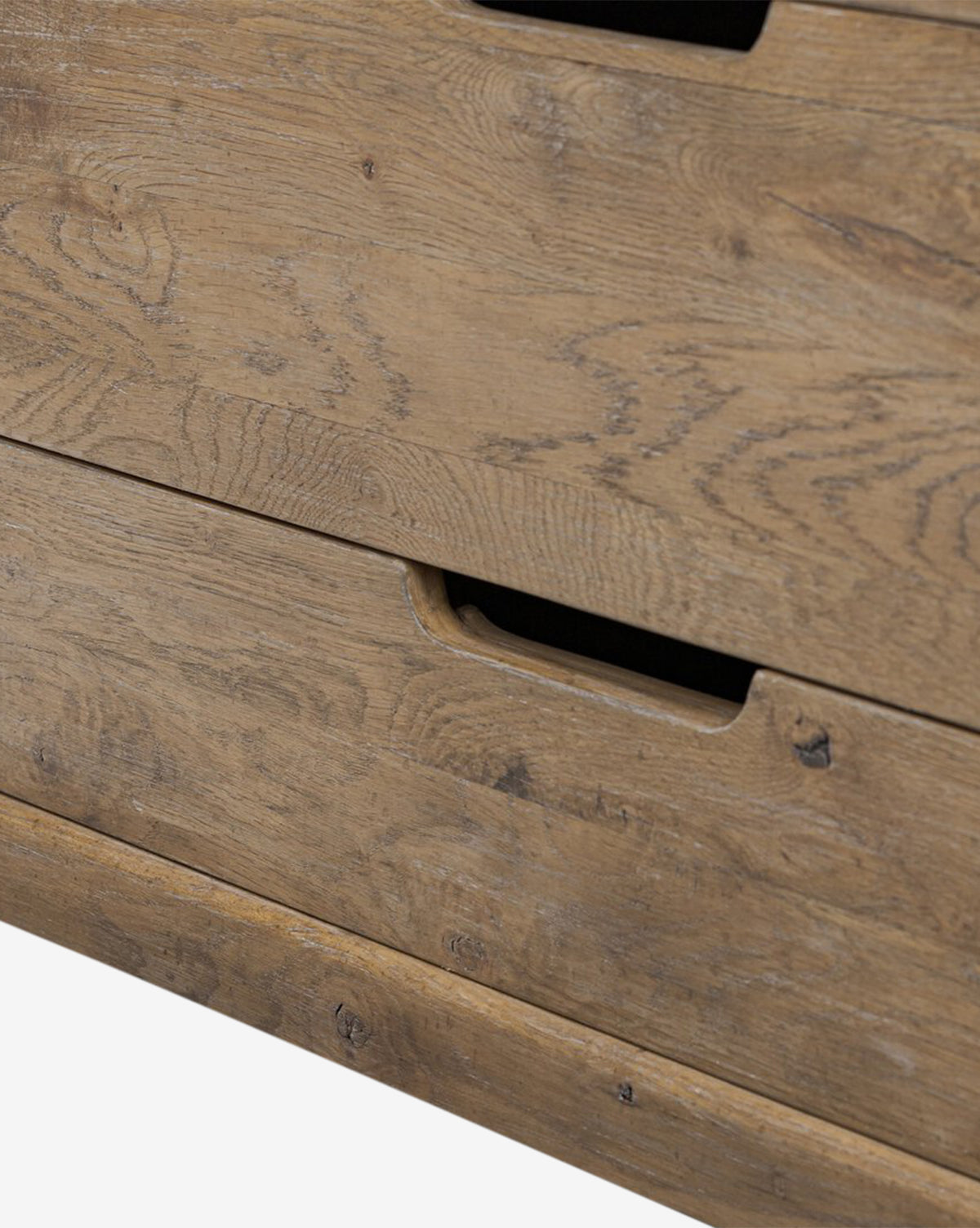 Close-up of the Sutton Trunk dresser in weathered oak, featuring two storage drawers with rectangular cut-out handles and a natural, rustic finish that highlights visible wood grain patterns, by Vendixs