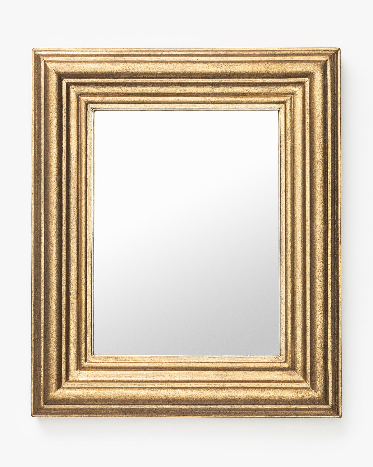 The Suzanne Shelf Mirror features a wide gold-finished rectangular frame with elegant ridged detailing, displayed against a plain white background by McGee & Co.