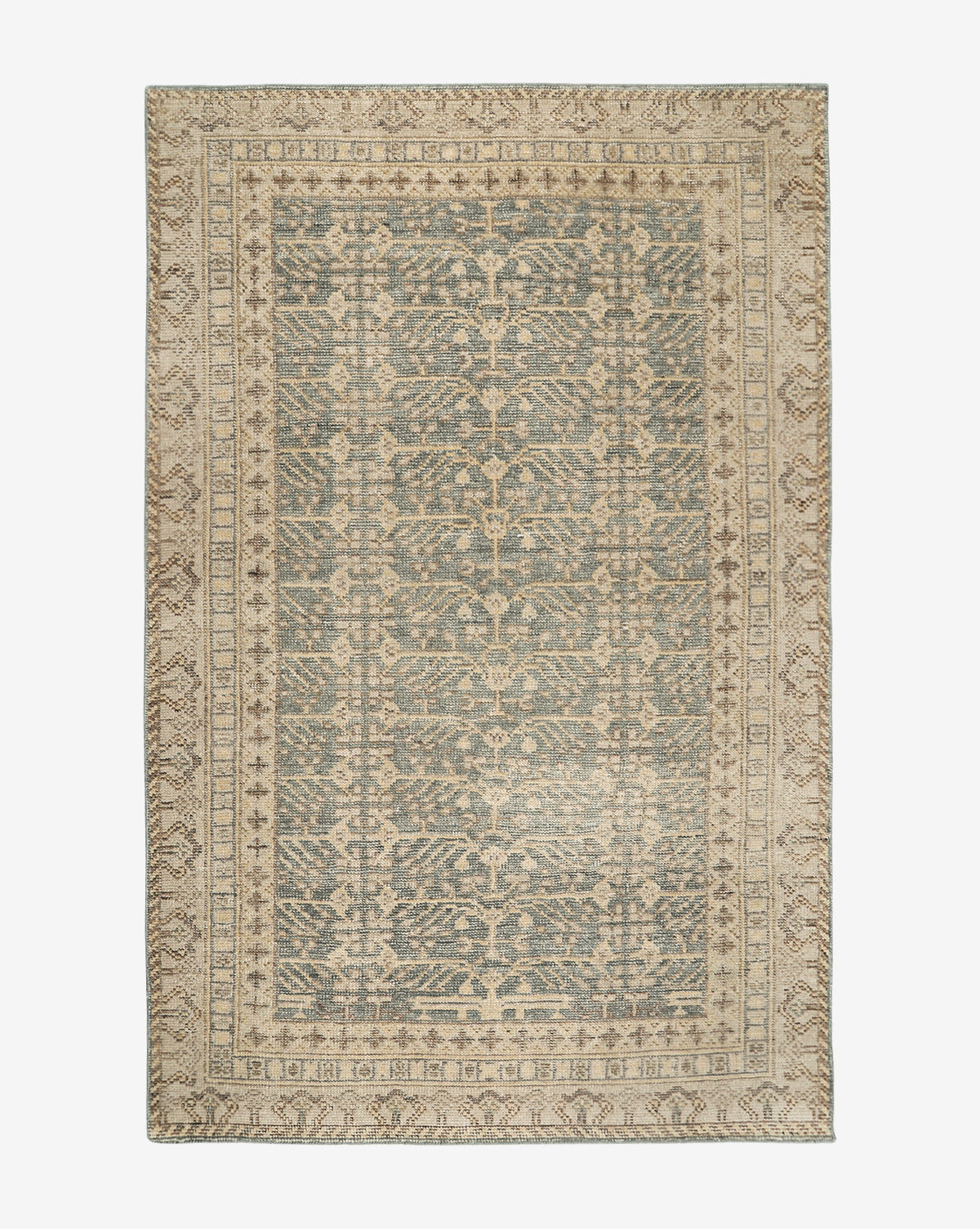 The Thames Hand-Knotted Rug features an intricate, symmetrical pattern in muted beige and blue tones, with a detailed border and central design—ideal for adding a touch of luxury to your home décor, by Vendixs