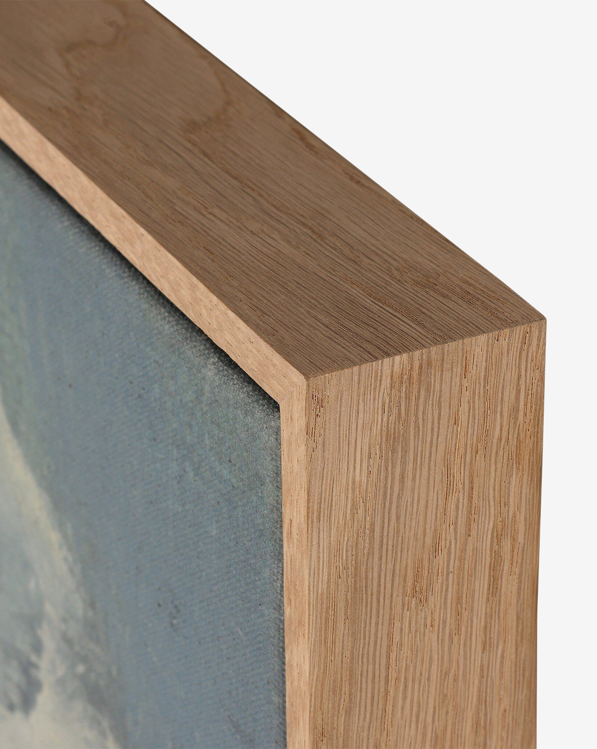 Close-up of the corner of a wooden picture frame with a natural finish, highlighting the texture of the wood and canvas surrounding The Long Way Home by Bethany Joseph, by Vendixs