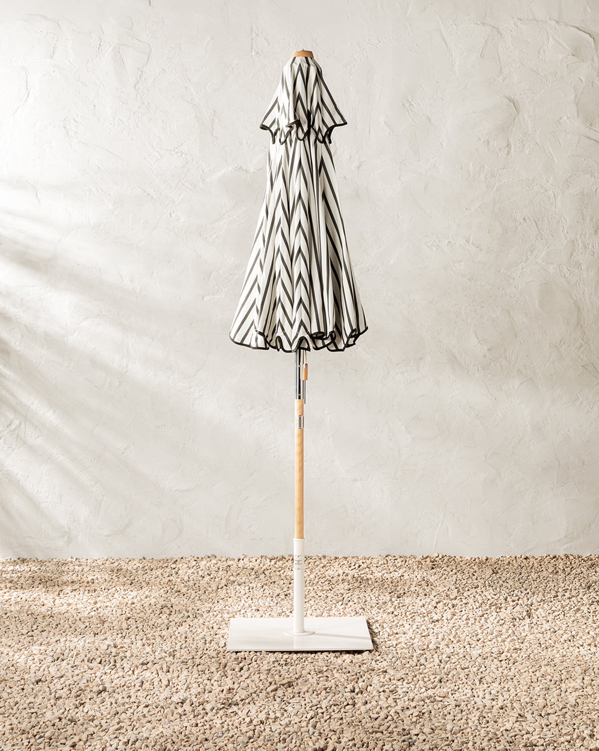 Patio umbrella shown closed black and white stripe to add style to outdoor spaces from Vendixs
