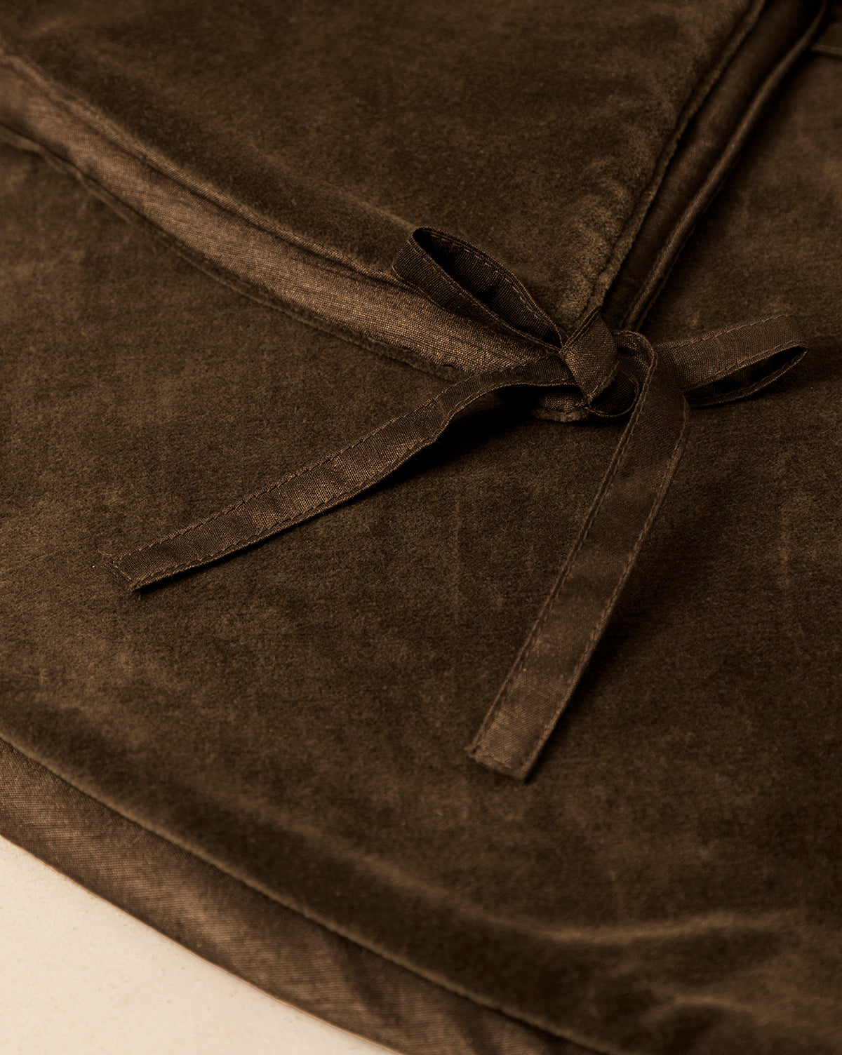 Close-up of the Velvet Brown Tree Skirt in dark velvet brown, featuring two neatly tied fabric straps—ideal for adding an elegant touch to your Christmas tree decor, by Vendixs