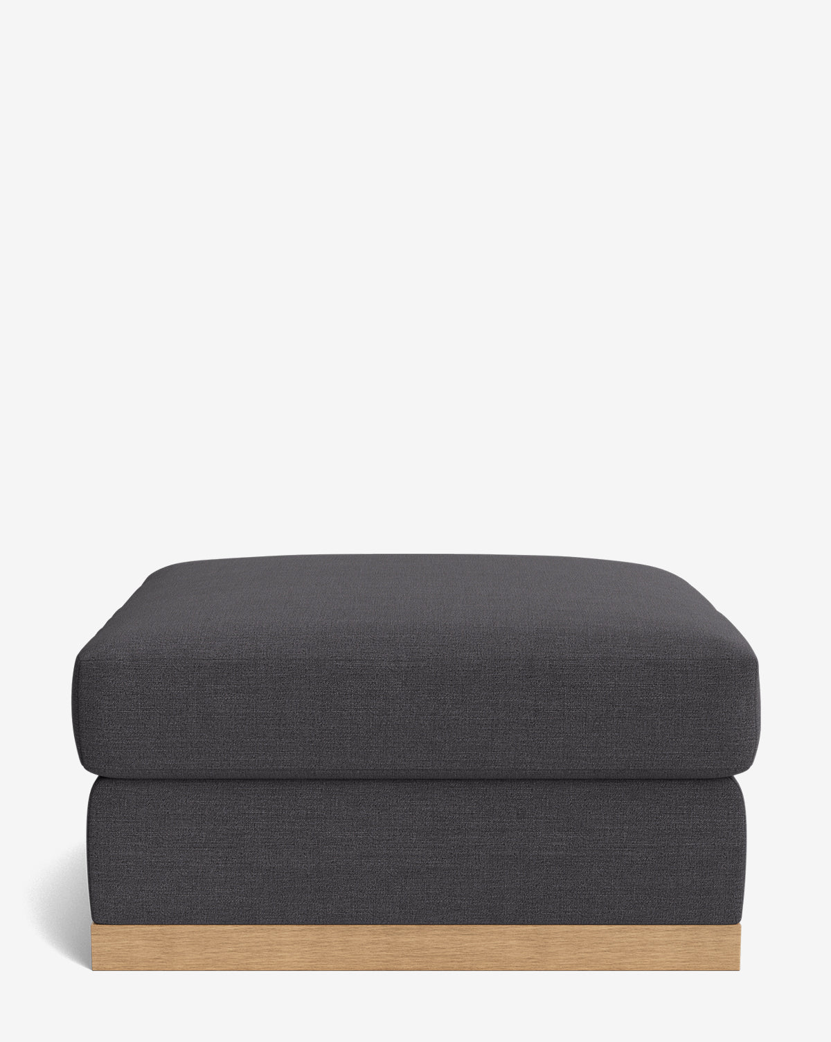 The Vernon Modular Ottoman, featuring a rectangular shape and dark grey upholstery with a wooden base, is shown against a plain white background by McGee & Co.