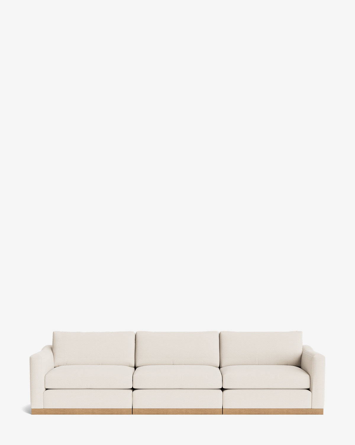 The Vernon Modular Sofa (121-157) is a modern three-seat sofa with low arms, upholstered in light beige fabric and set on a wooden base, shown against a plain white background by McGee & Co.