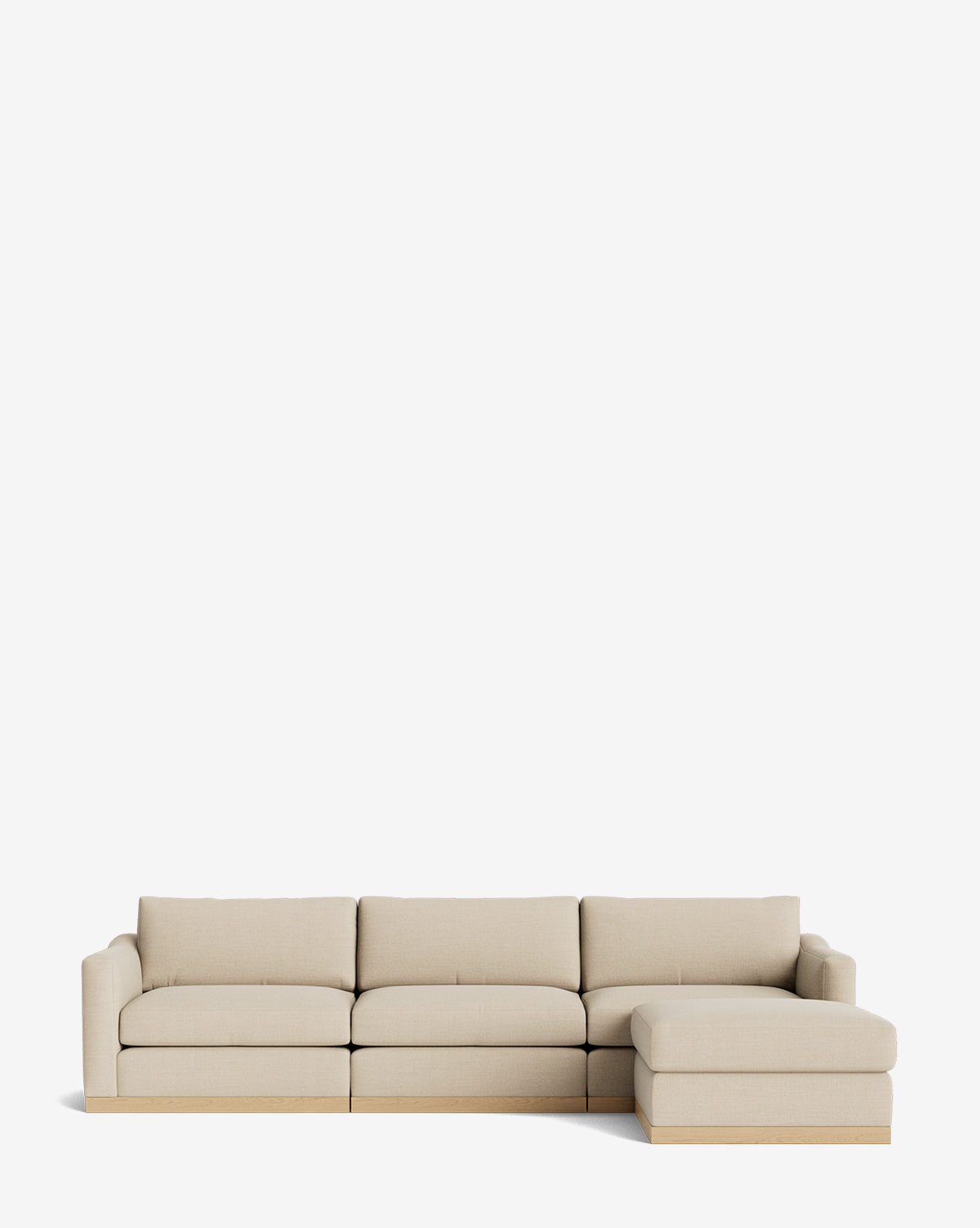 The Vernon Modular Sofa with Ottoman 121 is a modern beige sectional featuring clean lines, a right chaise lounge, a low light wood base, and customizable fabric—ideal for any contemporary space, by Vendixs
