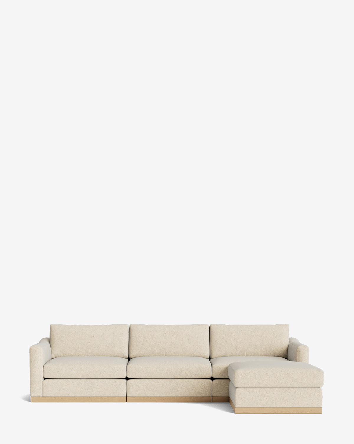 The Vernon Modular Sofa with Ottoman 121 in beige features four seat cushions, a right-side chaise lounge, simple lines, and a wooden base, offering customizable fabric options against a plain white background by McGee & Co.