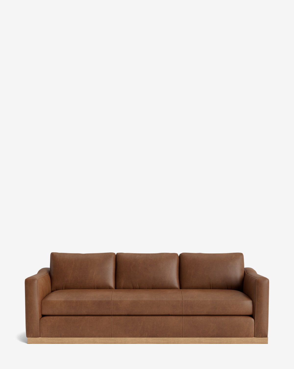 The Vernon Sofa 92 is a modern brown leather sofa with three seat cushions, low square arms, an alder wood frame, and a wooden base, shown against a plain white background by McGee & Co.
