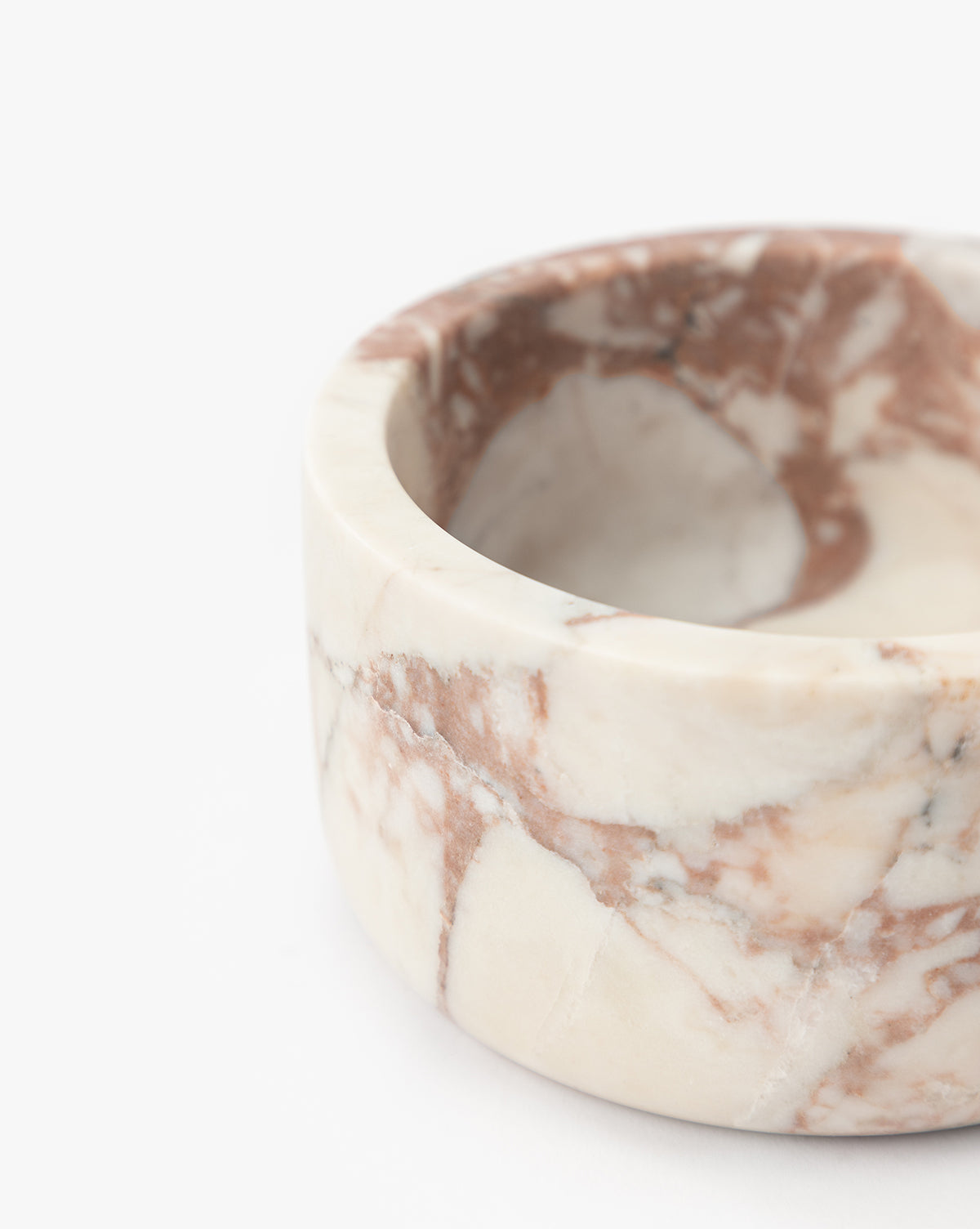 A close-up of the Verona Marble Bowl, a round piece with a matte finish and cream and brown veining, set against a white background, by McGee & Co.
