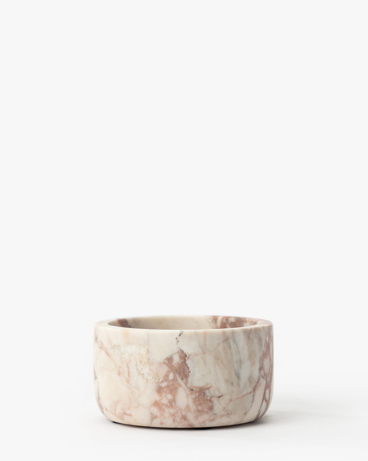 The Verona Marble Bowl is a round, shallow marble bowl with a matte finish and pink, white, and brown veining, displayed against a plain white background by Vendixs