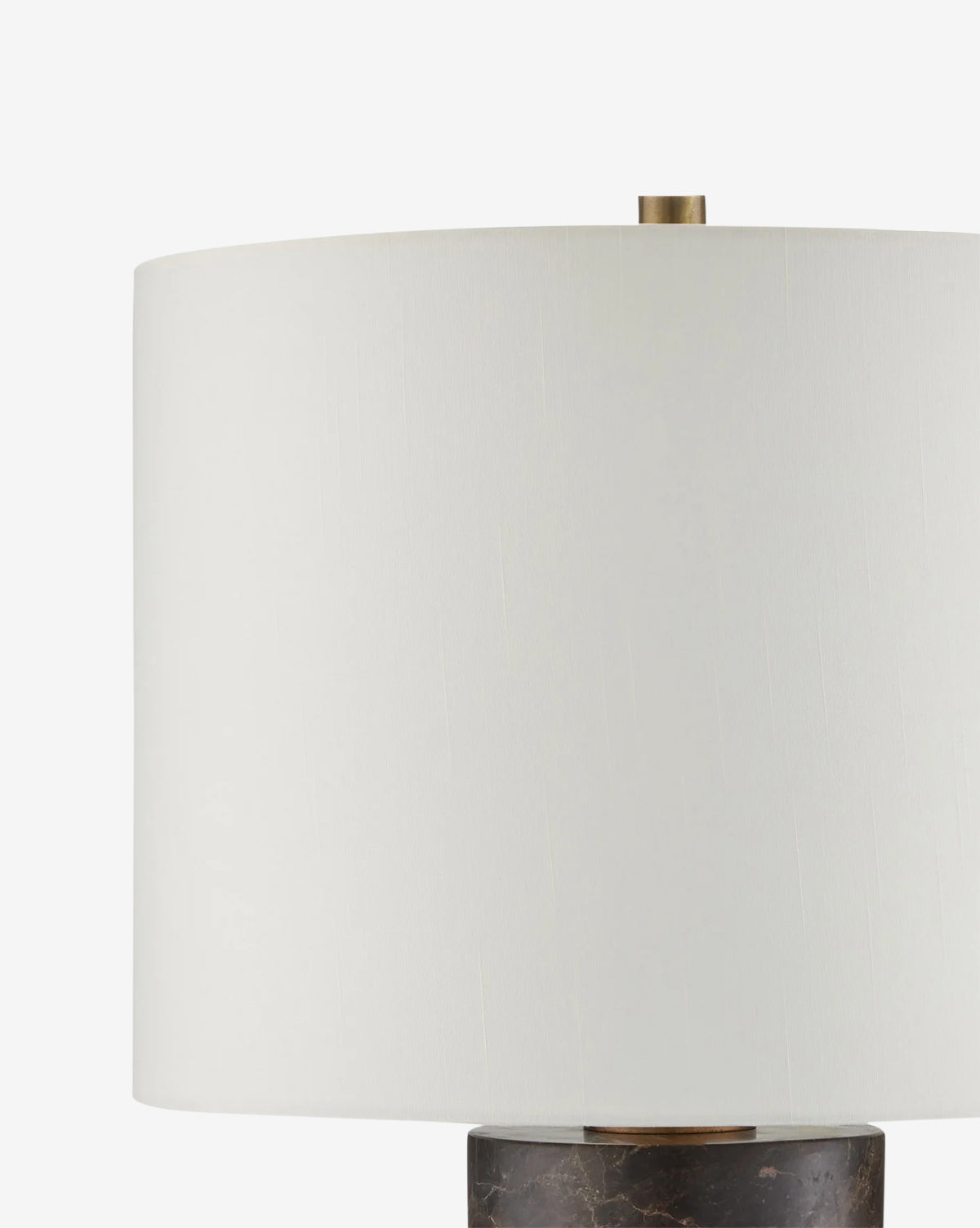 A close-up of the Vespera Table Lamp, showcasing its white cylindrical shade, antique brass accents, and dark marble column base against a plain white background, by Vendixs