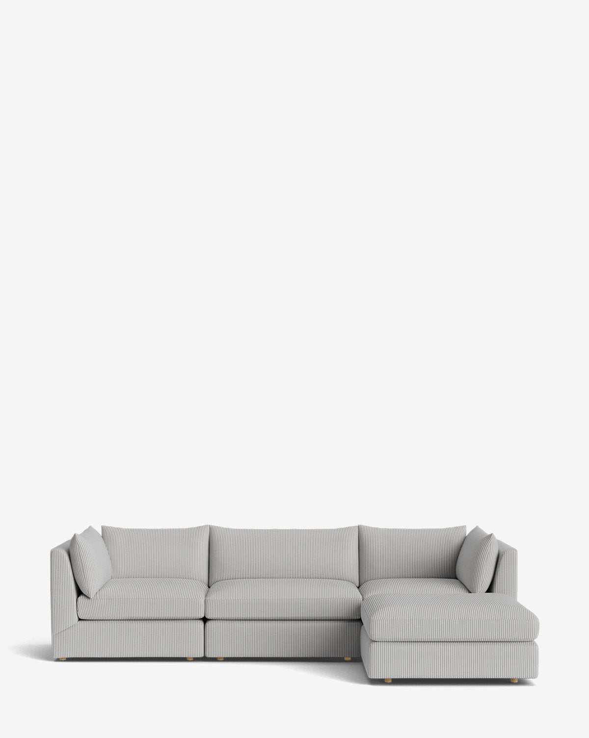 The Vivienne Modular Sofa with Ottoman features a modern design in light grey, ribbed upholstery, low backrest, matching cushions, and a right-side chaise lounge, all showcased against a plain white background by McGee & Co.