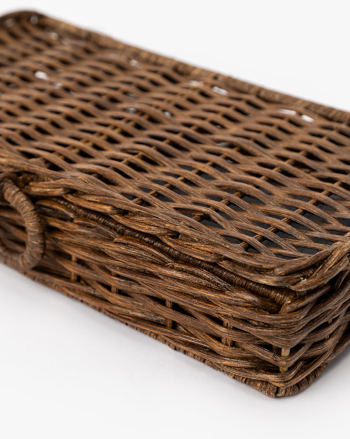 A close-up of the Windmere Woven Box, a rectangular brown wicker container with a woven pattern and rounded edges, displayed on a white background by McGee & Co.