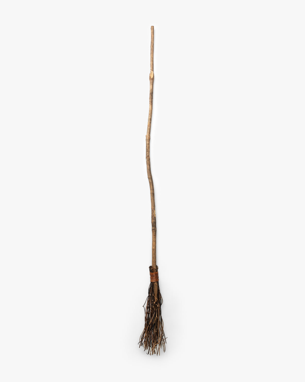 The Creative Co-op Witches Broom features a long, uneven wooden handle and twig bundle, making it ideal as handcrafted Halloween decor. Shown against a plain white background. Vendixs