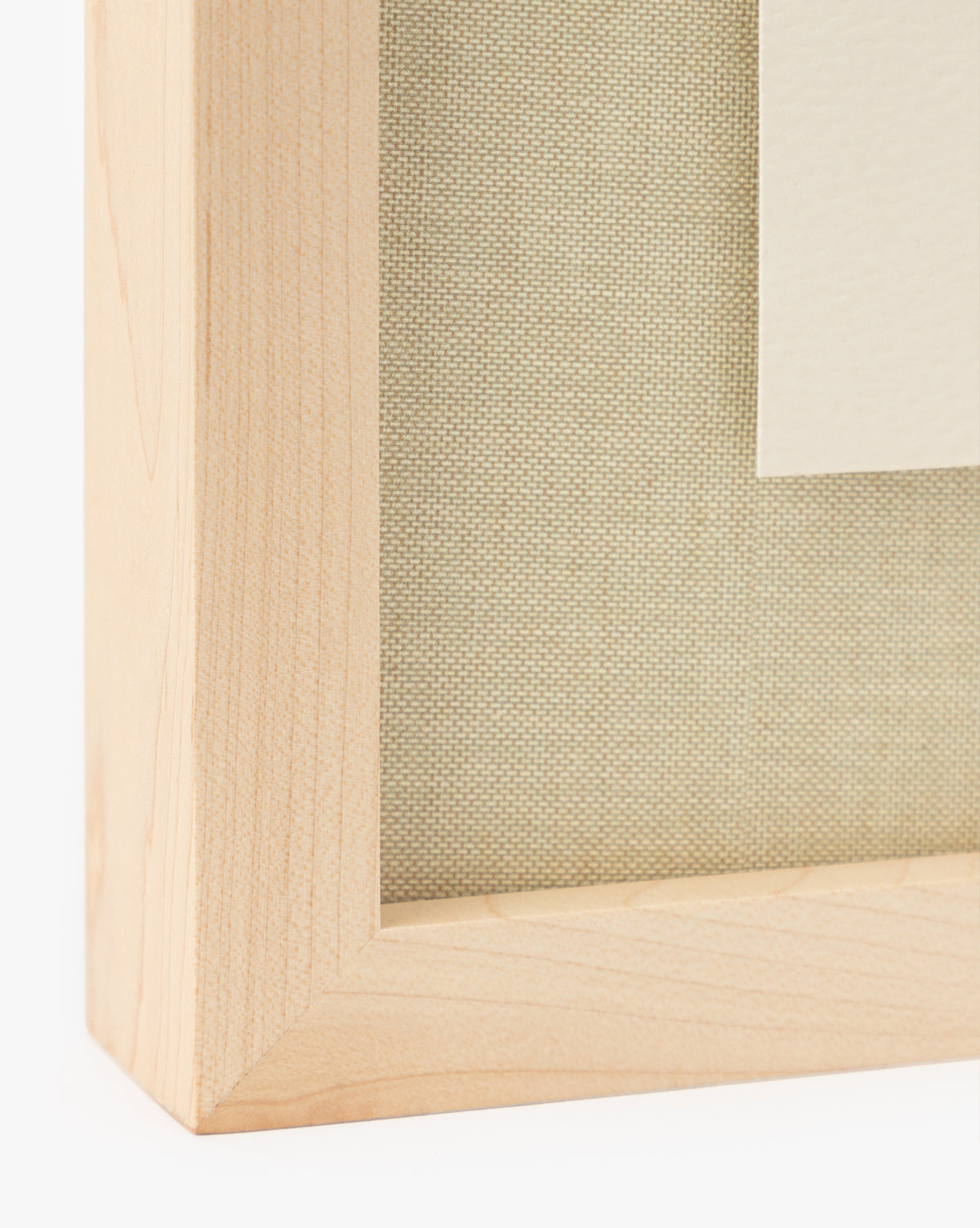 Close-up of the Woof light wood picture frame with its smooth finish, beige textured fabric backing, and a white mat—ideal for displaying fine art prints or framed wall art, by Vendixs