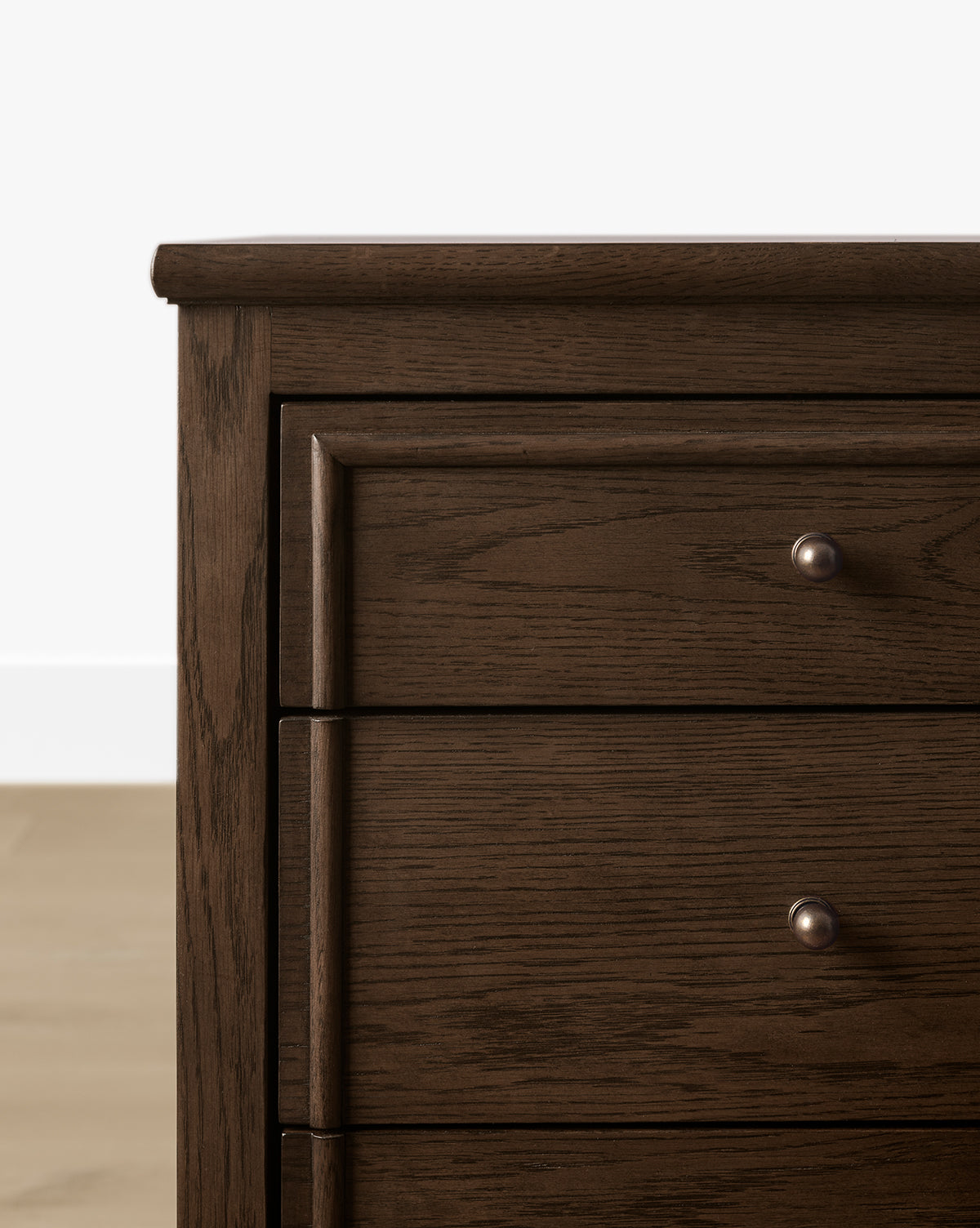 Close-up of the left side of the Yorkshire Dresser in English oak finish, featuring three drawers with round metal knobs, set against a white wall and light wood floor—perfect for stylish bedroom storage, by Vendixs