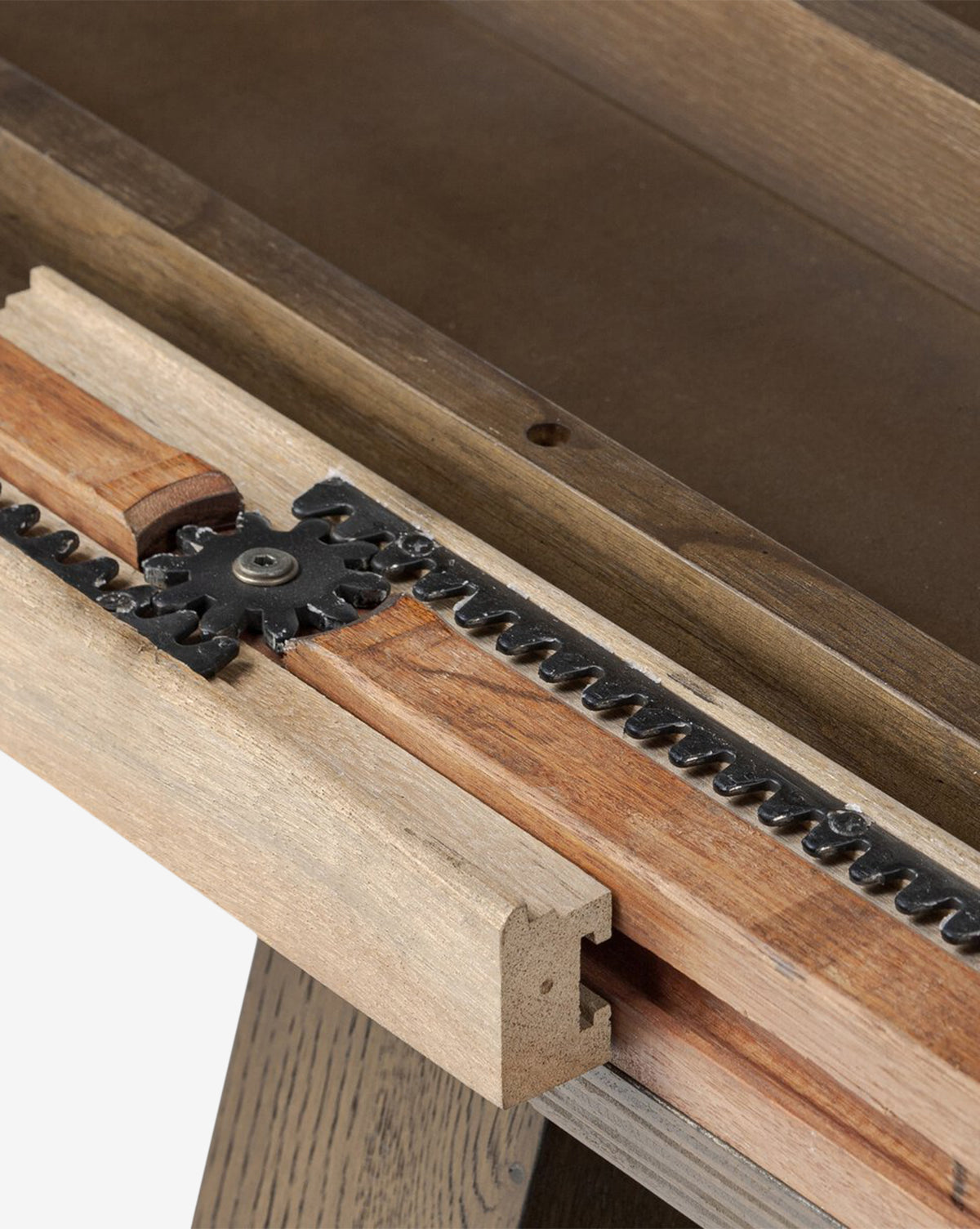 Close-up of the Yvonne Dining Tables wooden mechanism, highlighting a metal gear and toothed track, detailed craftsmanship, oak woodgrain, and a rich dark finish as part of its extension feature, by Vendixs
