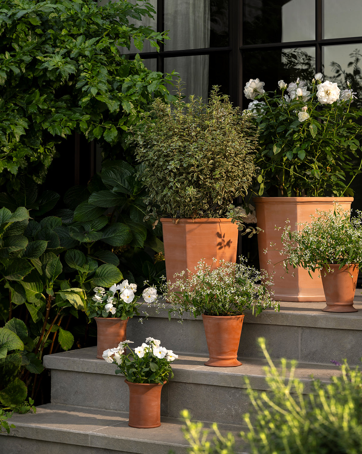 Pair of Dempsey Planters in terracotta, styled outdoors on a patio with greenery, from Vendixs