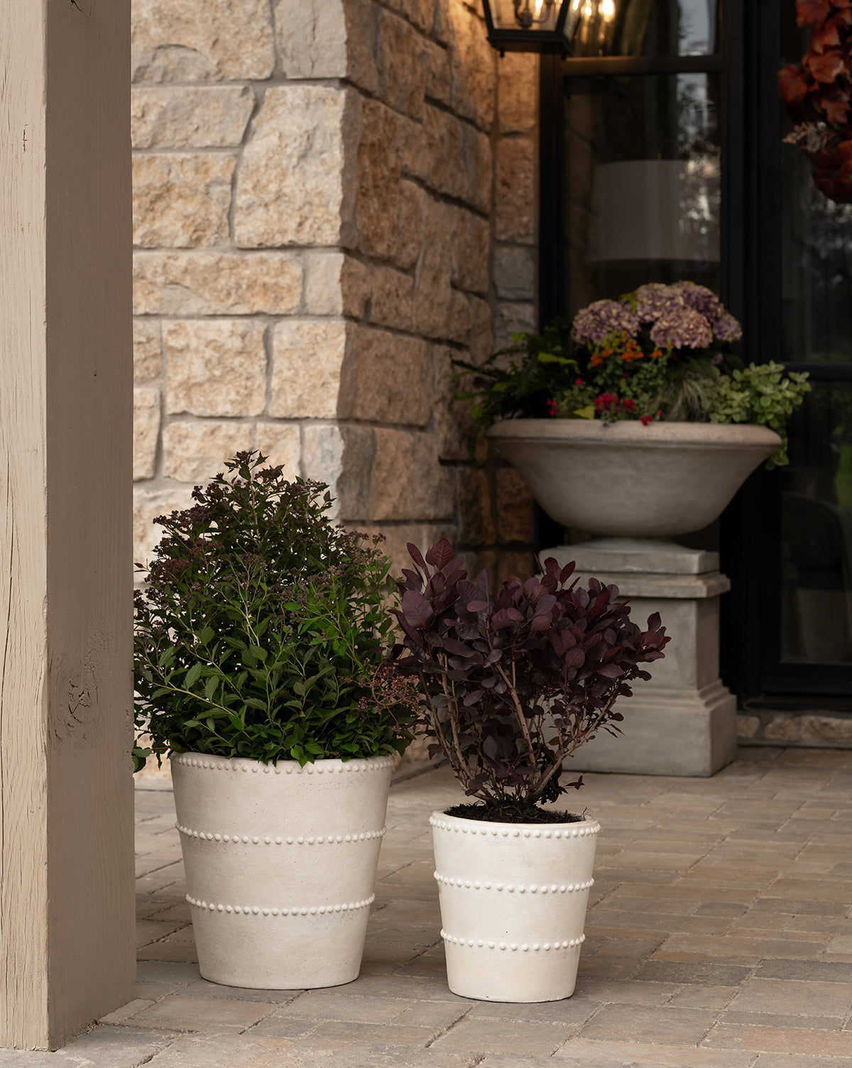 Allston Planter with terracotta finish, shown on a porch in large and small sizes from Vendixs
