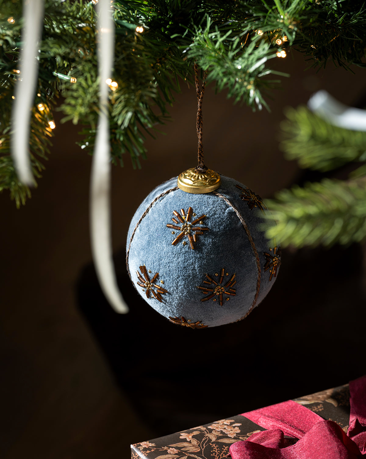Small white lights twinkle nearby, while a pink-ribboned gift below completes the vintage-inspired scene, by Vendixs