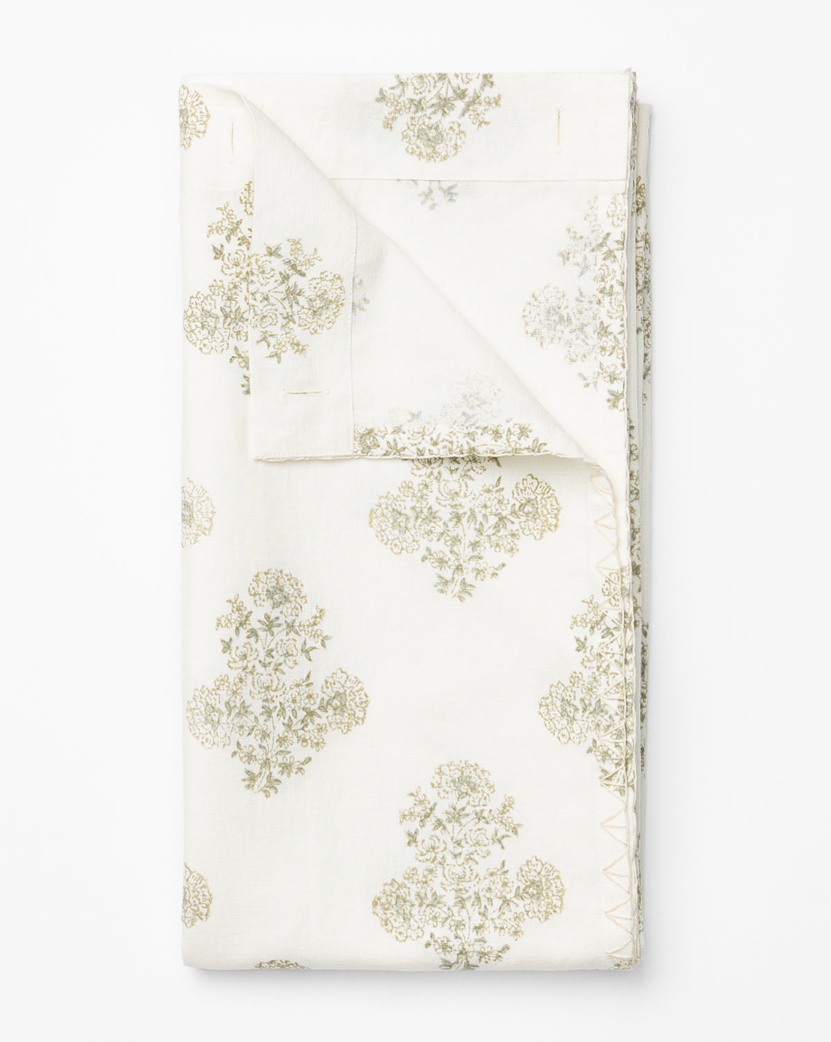 The Block Print Shower Curtain features folded white fabric with a subtle, repeating light green floral pattern—perfect for vintage bathroom decor. A turned-up corner reveals the consistent design on both sides.