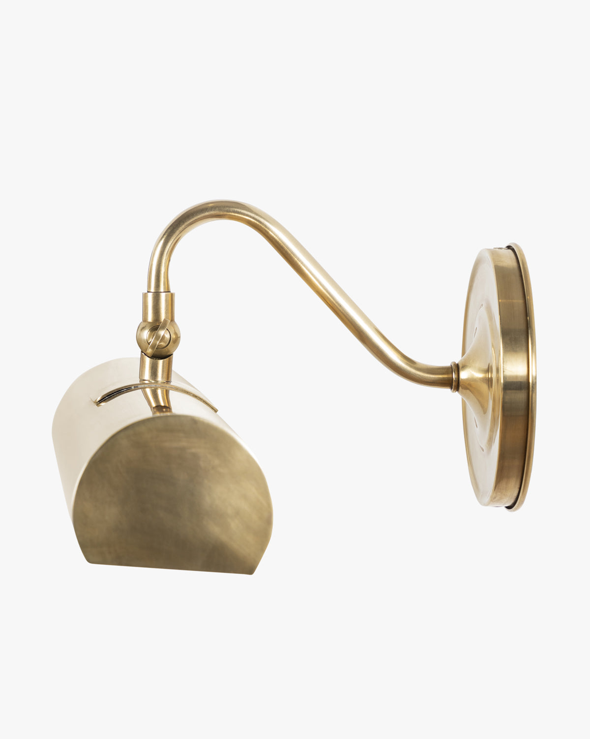 The Gallery Picture Sconce features a curved brass arm and semi-oval cylindrical shade. Its matte finish and minimalist design evoke burnished bronze, offering a modern update to the classic wall-mounted sconce style, by Vendixs