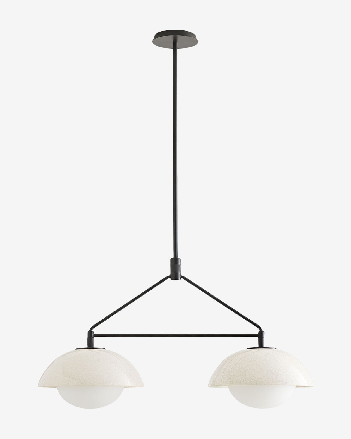 The Arteriors Glaze Linear Pendant features two white globe lamps, each partially covered by a crackled glaze ceramic dome, suspended from a black rod and frame for a modern look. Vendixs
